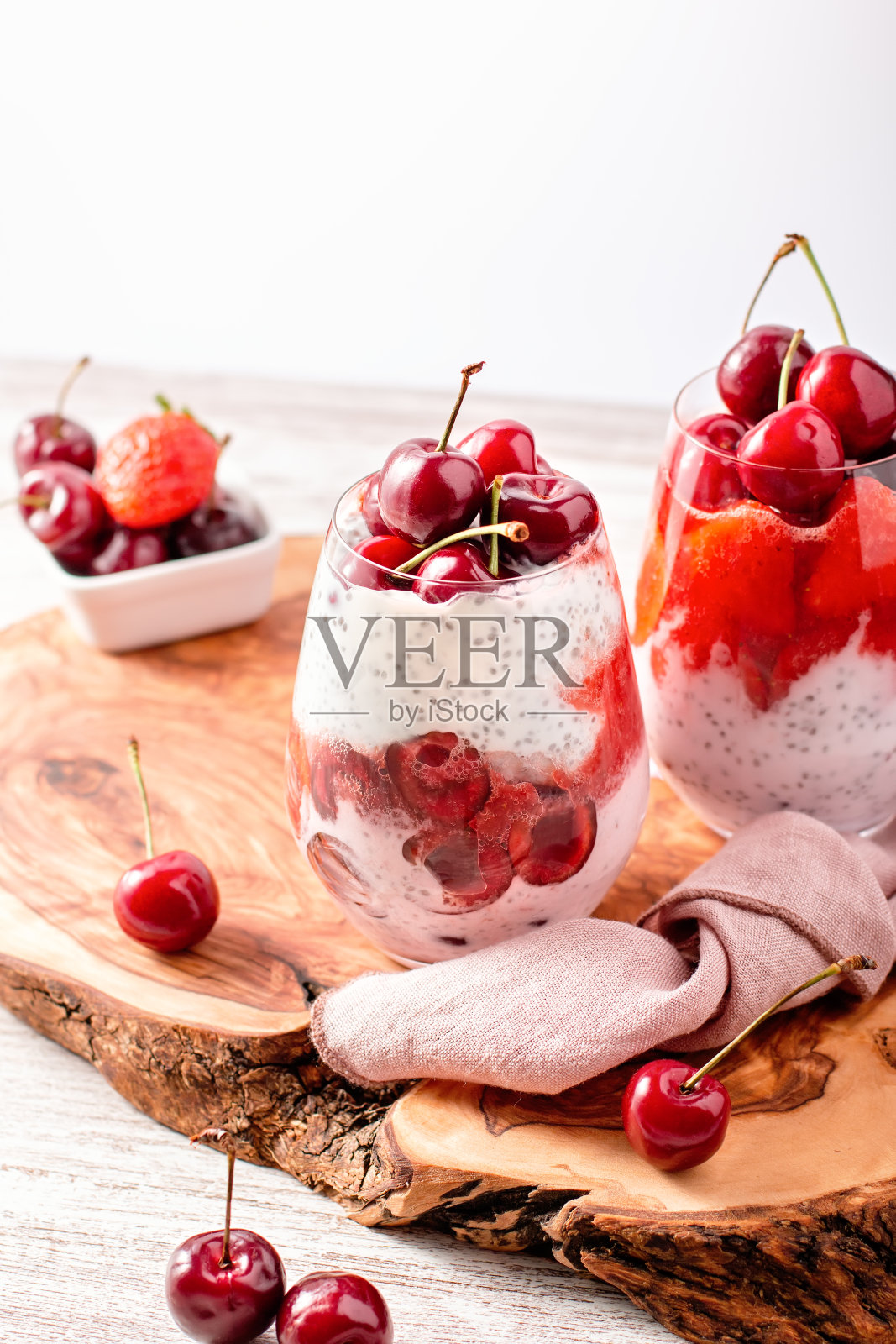 奇亚籽，樱桃和草莓分层布丁在玻璃杯放在桌上照片摄影图片