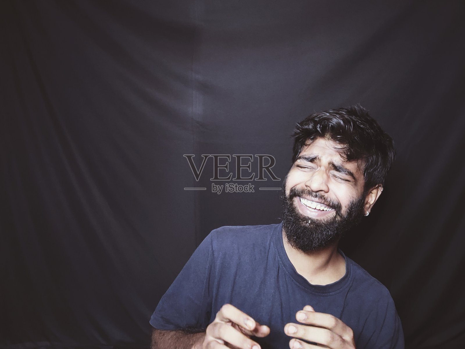 印度一名蓄着胡须的男子，他在社交媒体上发布帖子和网络横幅照片摄影图片