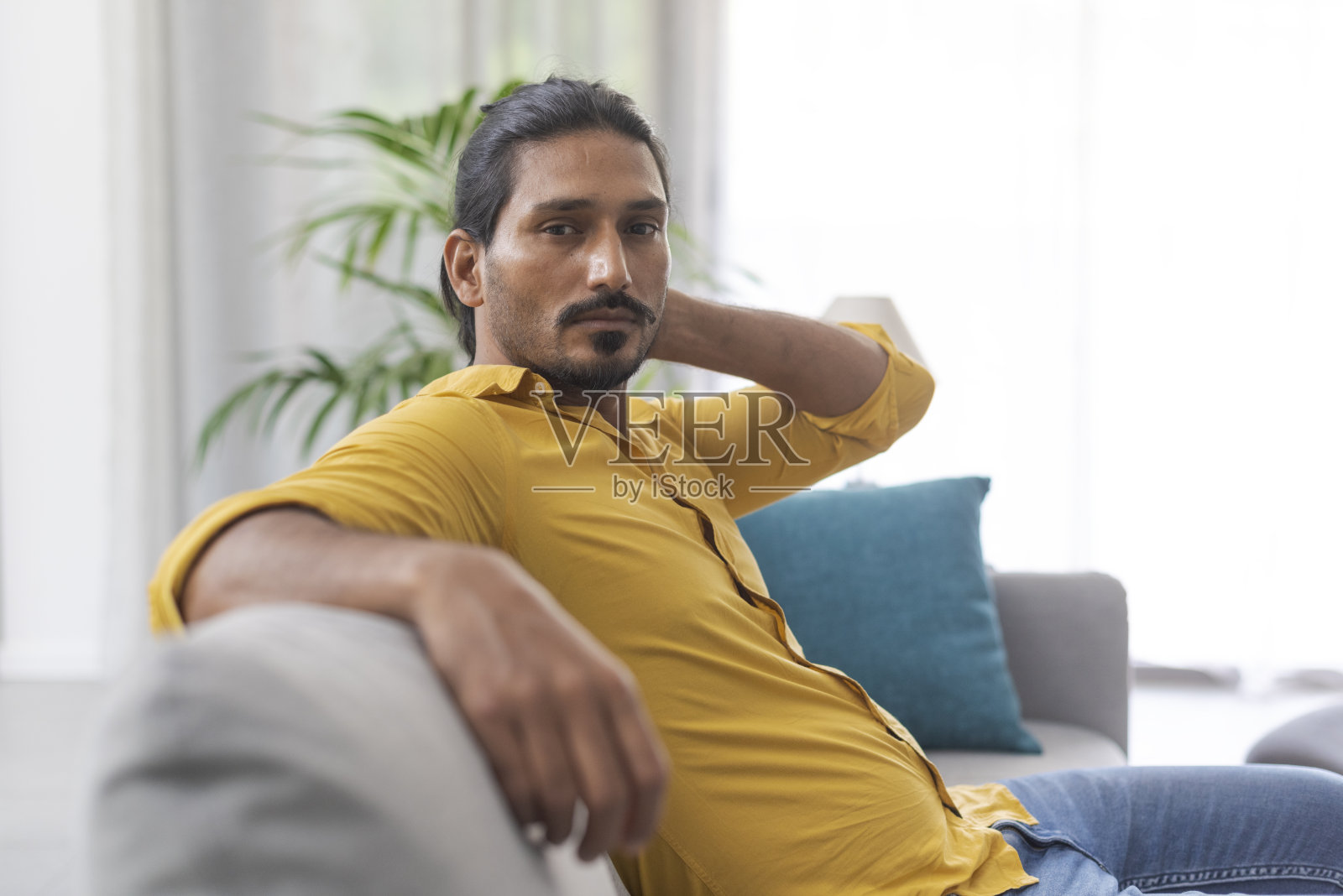 自信的男人坐在沙发上看着摄像机照片摄影图片