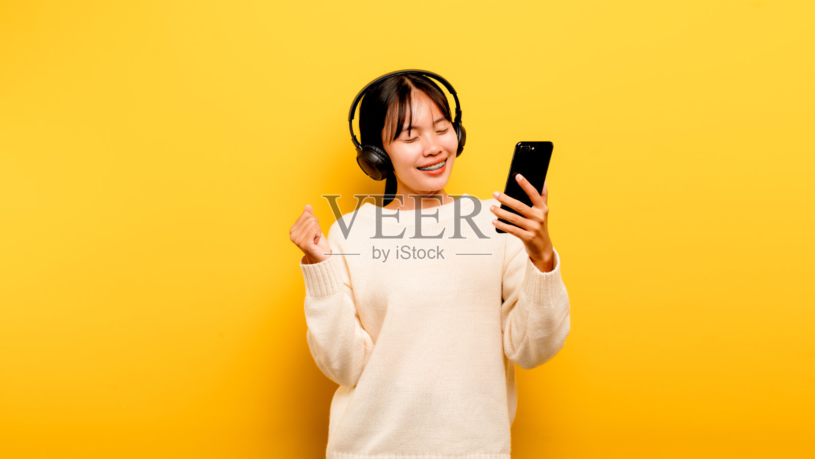 亚洲女人愉快地使用电话和听音乐放松与音乐。在一个舒适的日子。舞蹈和放松的概念。在线听音乐照片摄影图片