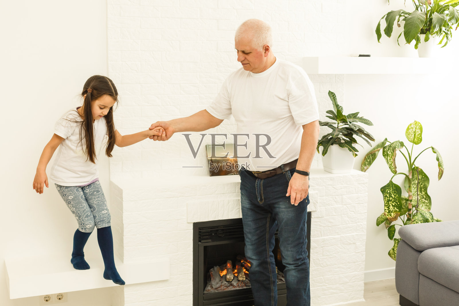 小孙女拥抱着她的爷爷照片摄影图片