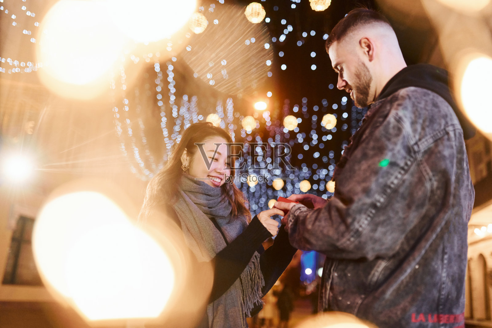 礼物盒。幸福的多种族夫妇一起在城市户外庆祝新年照片摄影图片
