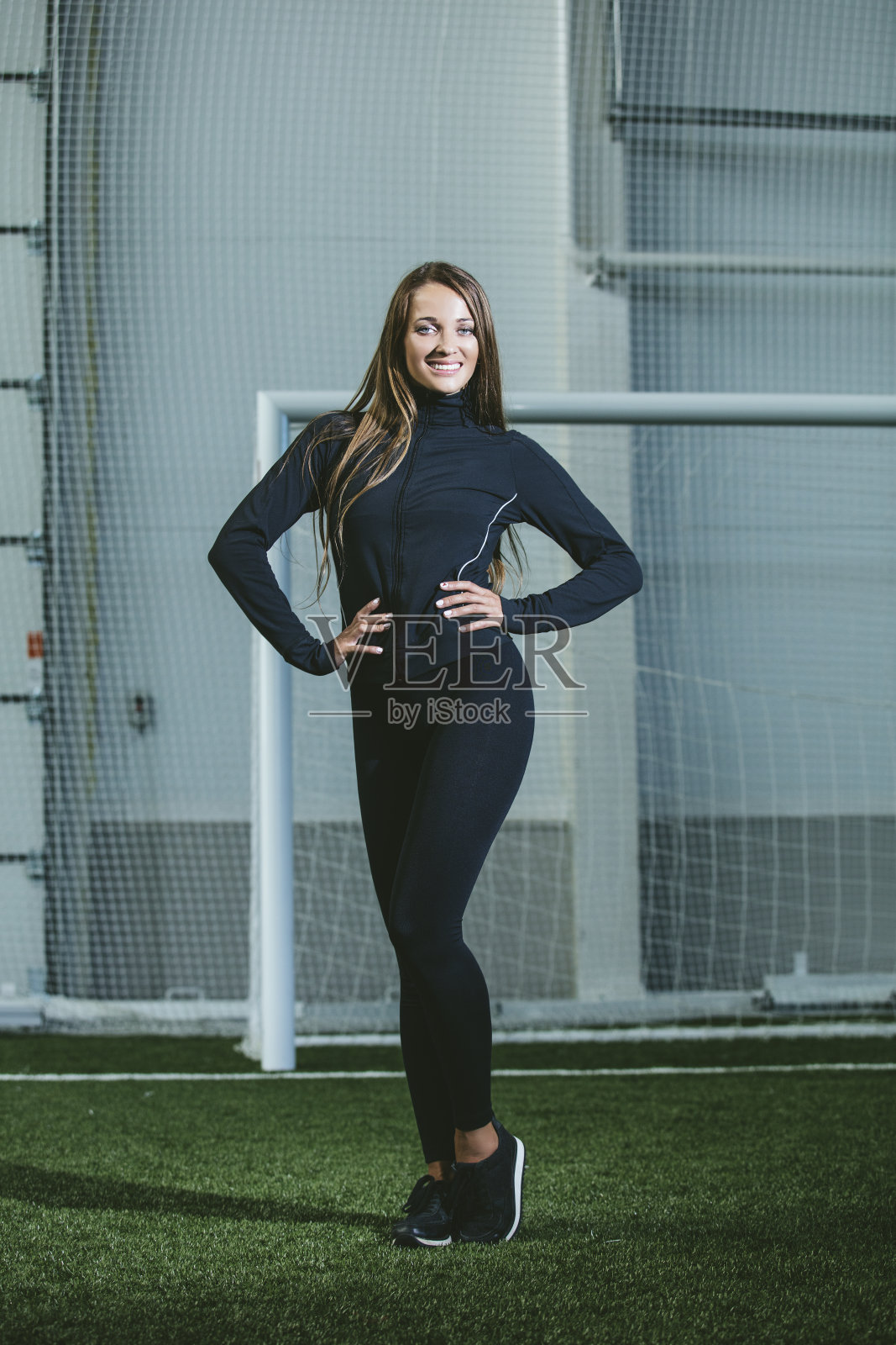 漂亮苗条的年轻女子穿着运动服在体育场里忙碌照片摄影图片