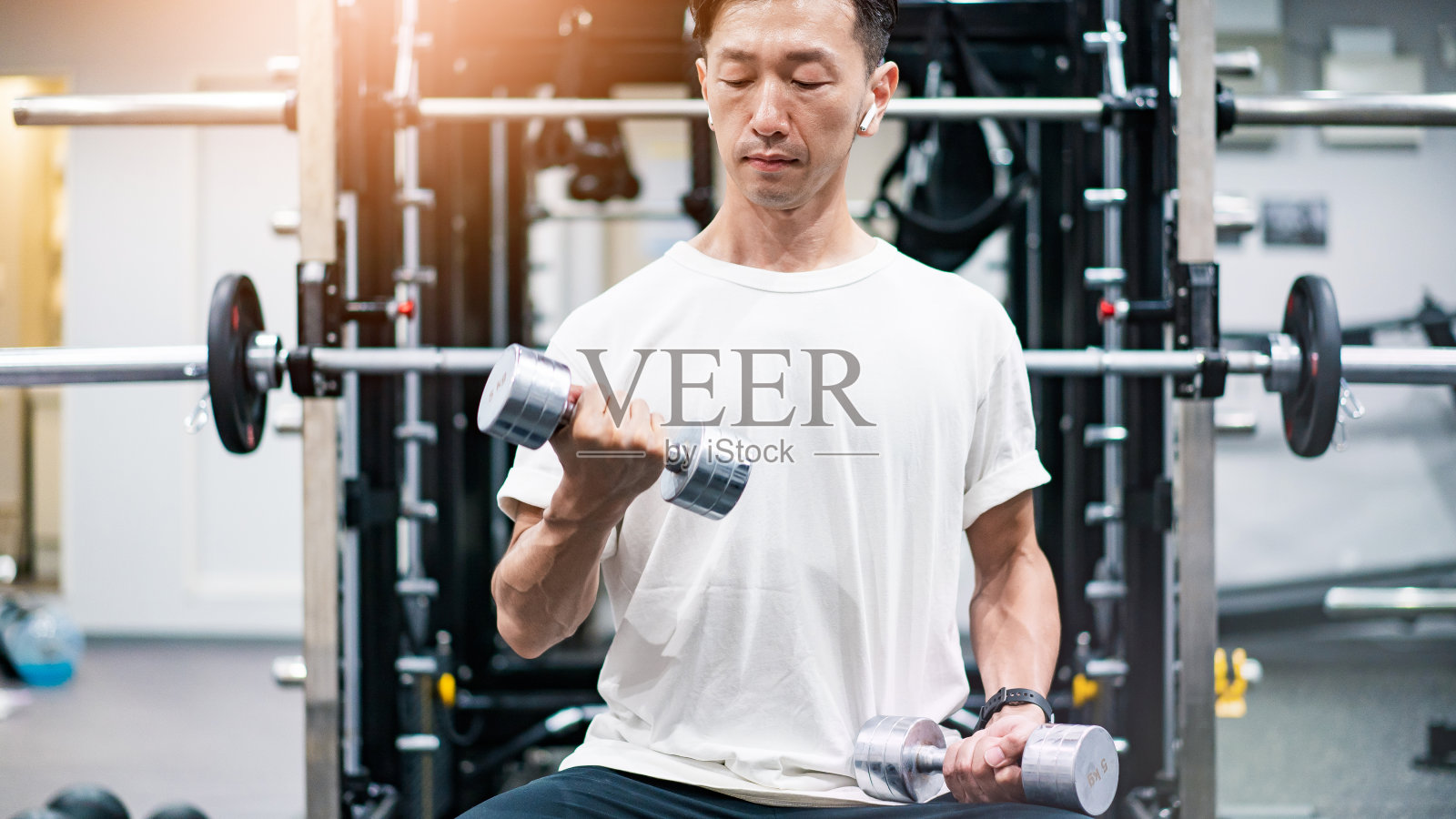 男子用哑铃做肌肉训练照片摄影图片