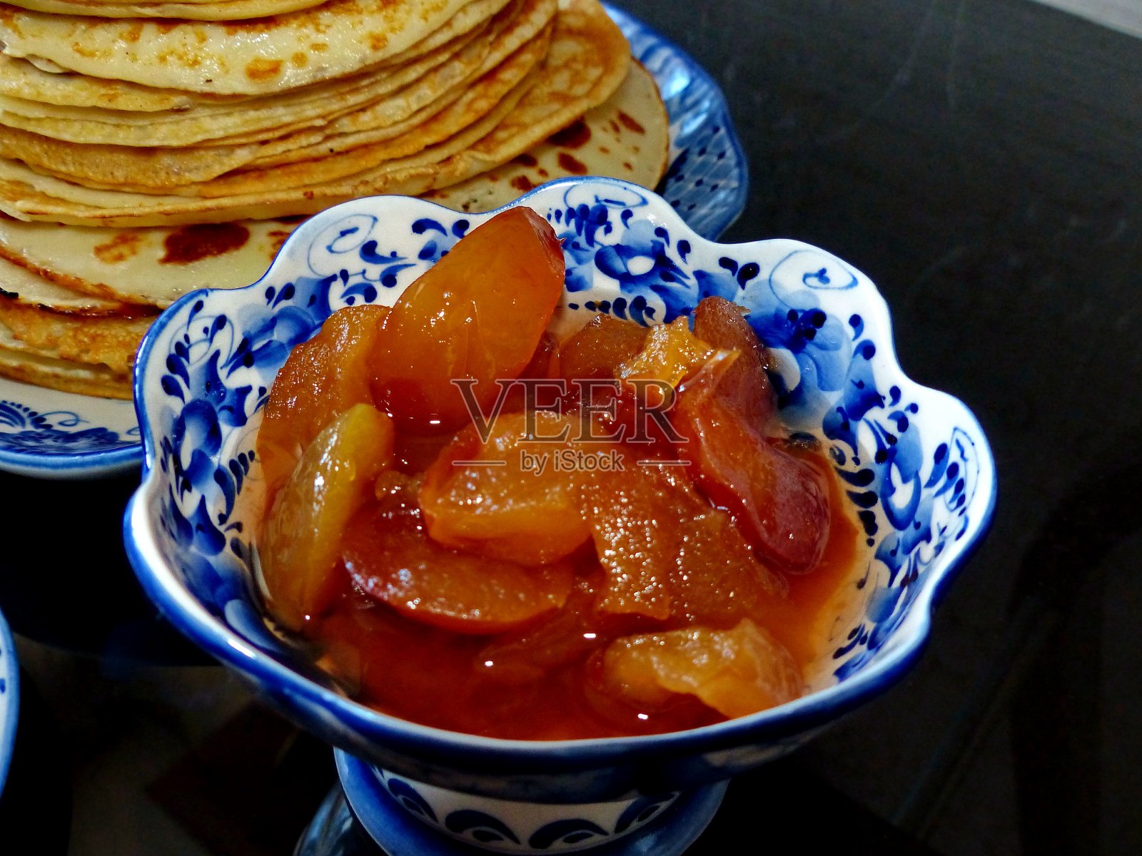 煎饼和果酱。忏悔节。Maslenitsa是一个传统的东部斯拉夫节日，在大斋节前一周庆祝。俄罗斯传统Gzhel风格的餐具——用于生产陶瓷和瓷器的民间工艺照片摄影图片