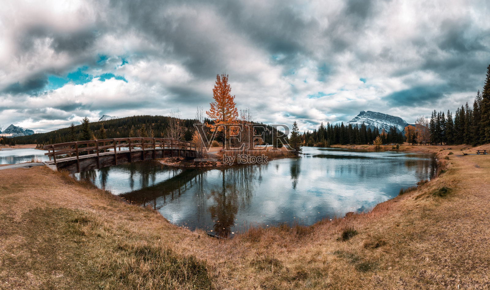 班夫国家公园里的瀑布池塘、伦德尔山、木桥和引人注目的天空照片摄影图片