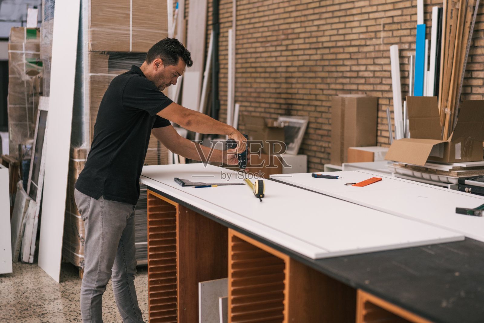 工人在车间的白色表面上使用钻头照片摄影图片