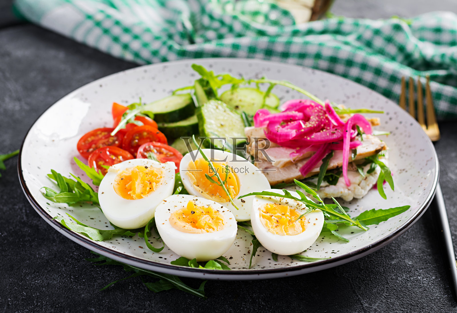 早餐。水煮蛋蔬菜沙拉，黄瓜，西红柿，意大利乳清干酪三明治，炸鸡片和红洋葱。酮/化石午餐。照片摄影图片