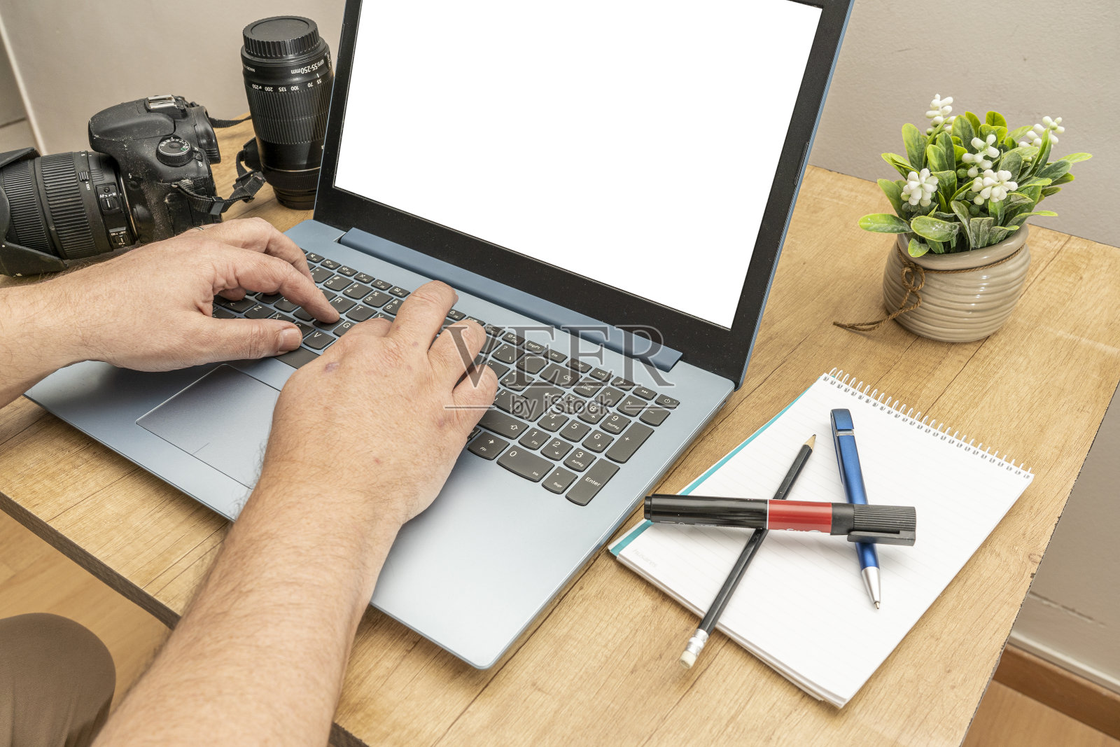 一个在家用笔记本电脑工作的男人。他在键盘上写字。技术和通讯概念。照片摄影图片