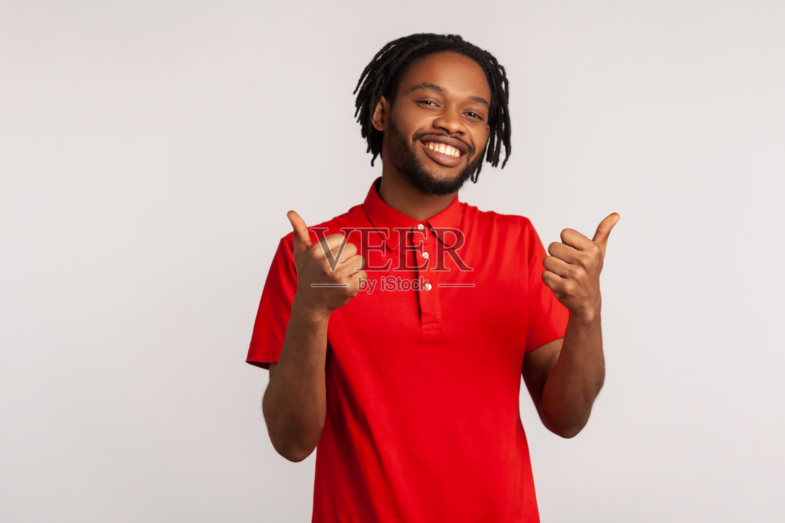 留小胡子的帅哥，梳着雷辫，穿着红色休闲风格的t恤，竖起大拇指，有批准标志，对服务很满意，反馈很好。照片摄影图片