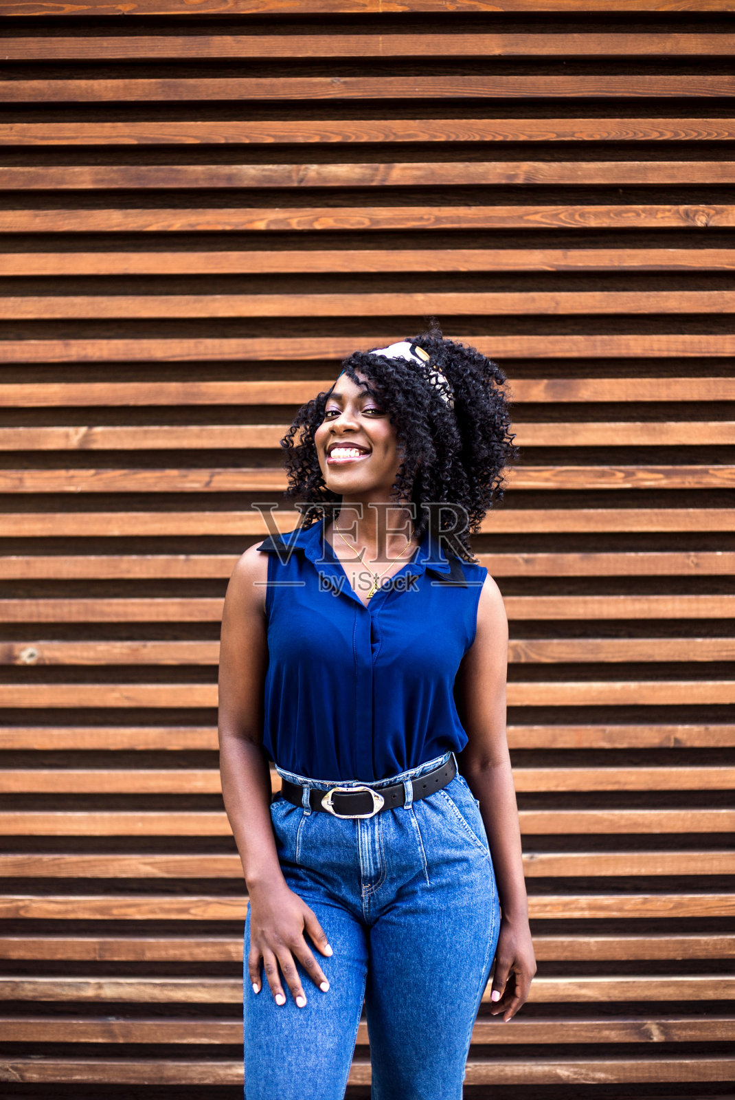 一个年轻快乐的黑人妇女的肖像在木制背景。照片摄影图片