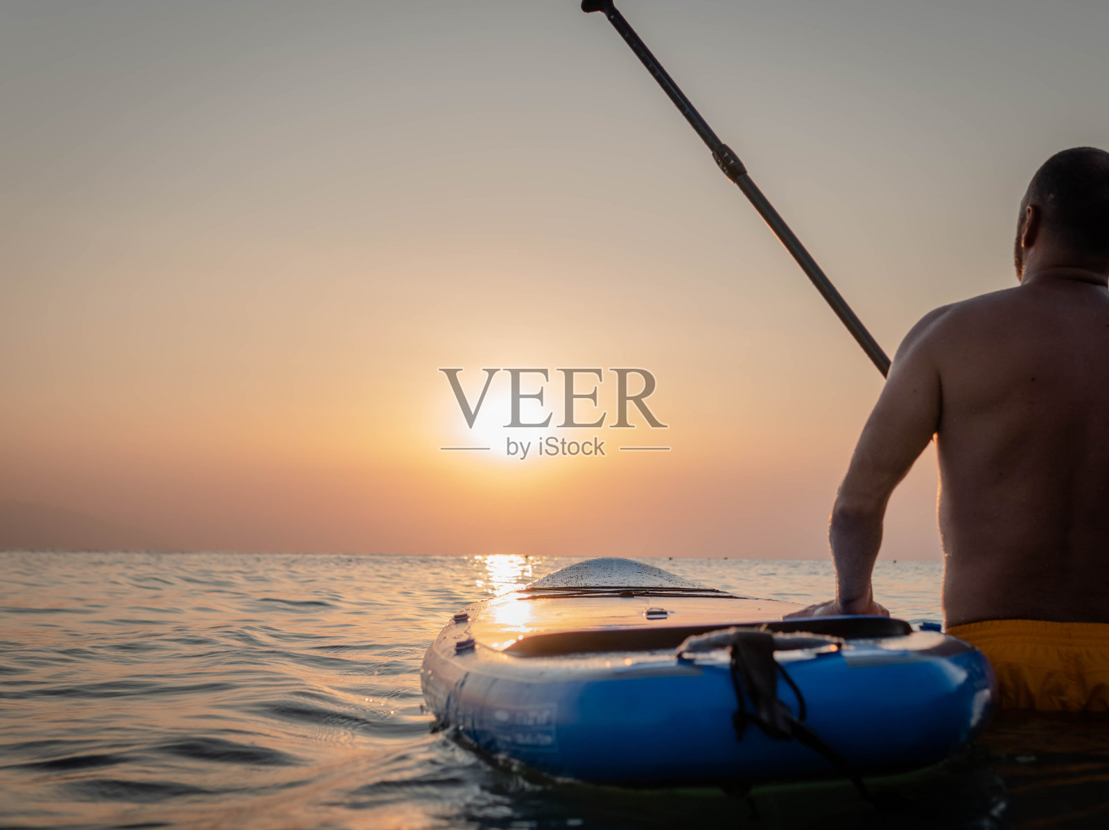 日落时男子划桨的剪影照片摄影图片