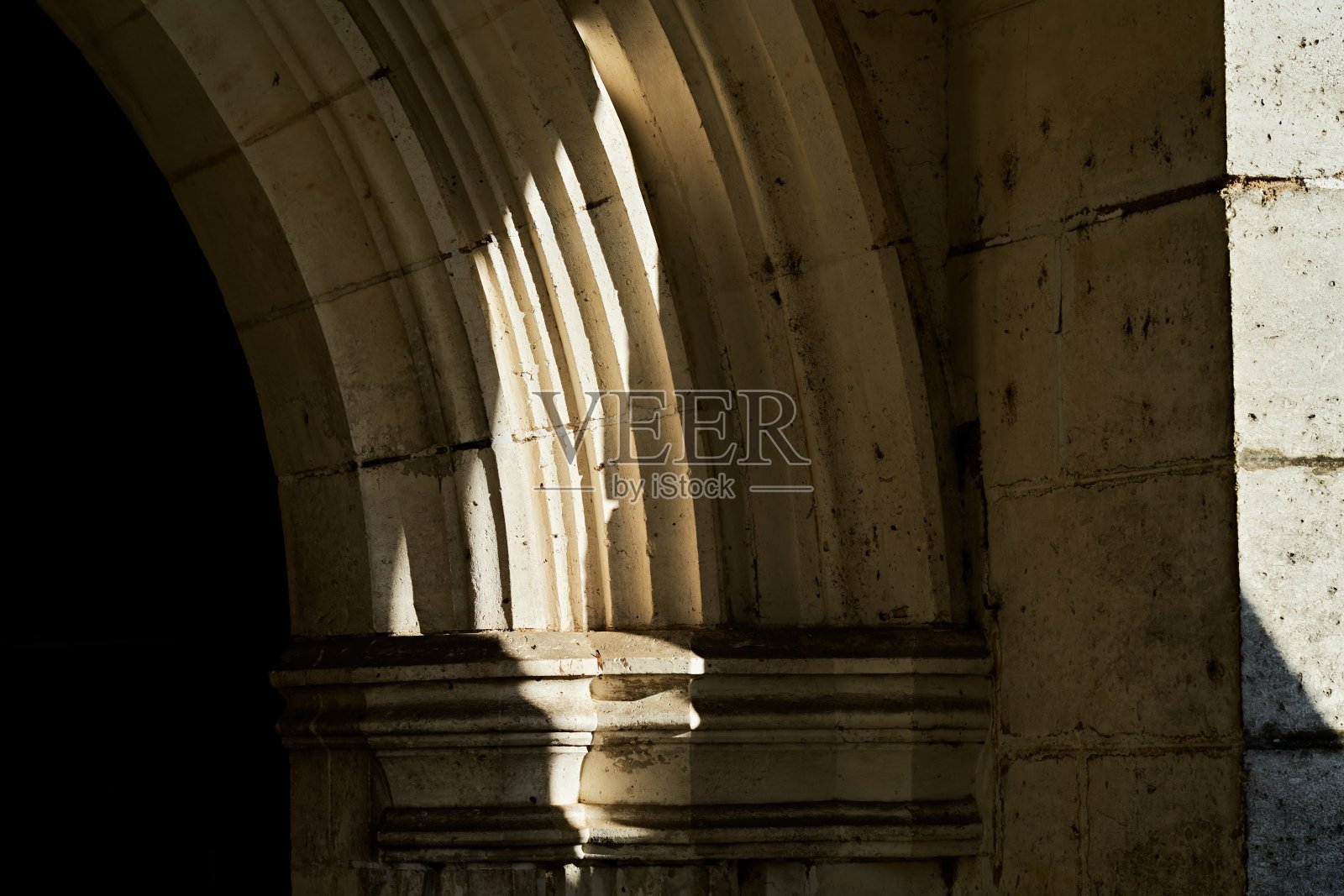 阳光在教堂大门华丽的石拱上投下阴影照片摄影图片