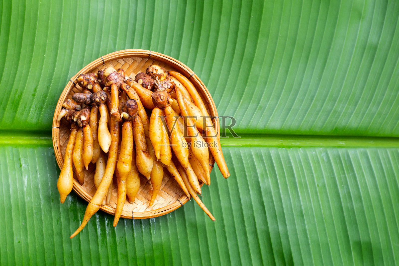 指根放在竹篮里，放在香蕉叶上照片摄影图片