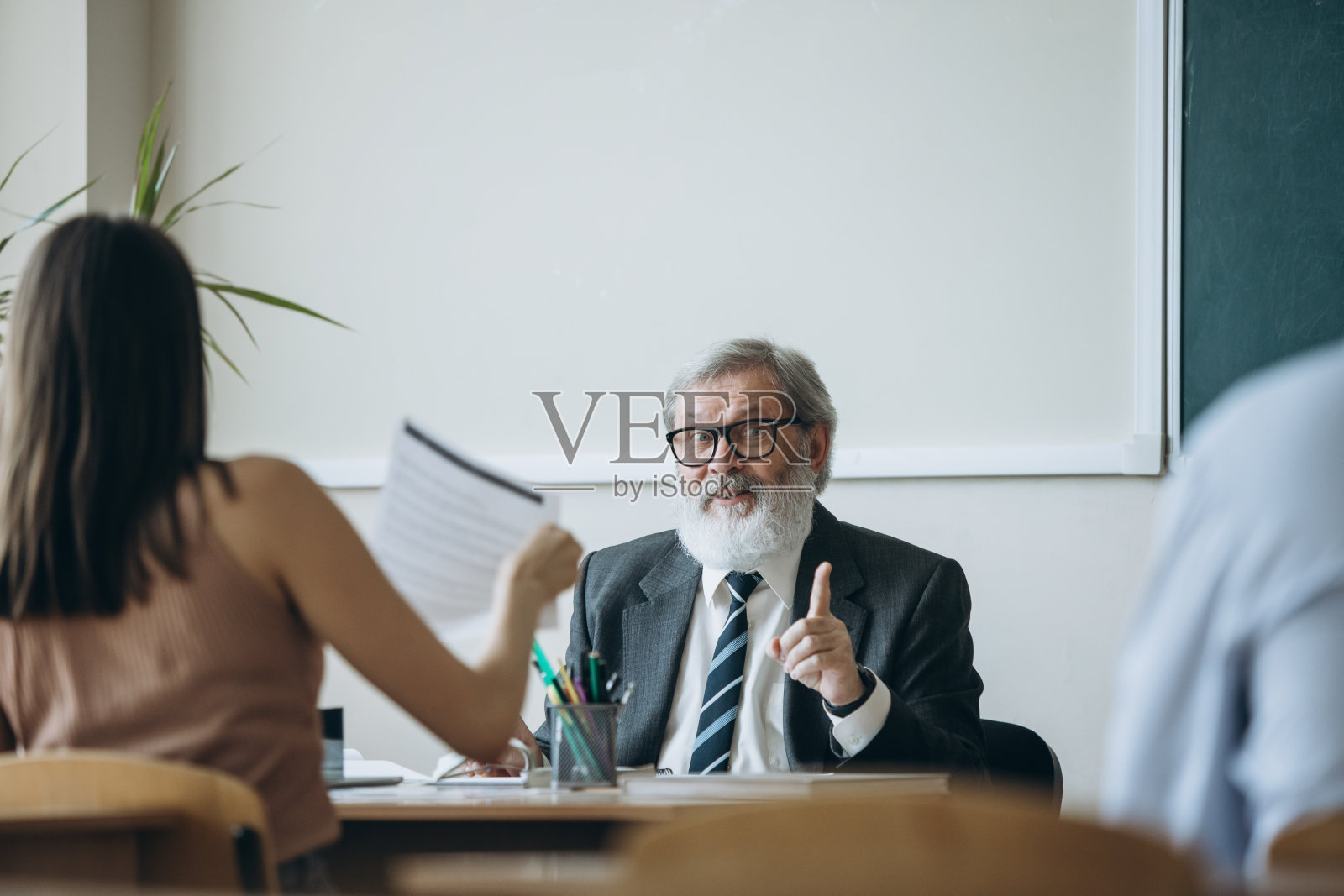 白发苍苍的老人、教授、老师和学生在上课、在教室上课、在室内上课。职业、职业、教育的概念照片摄影图片