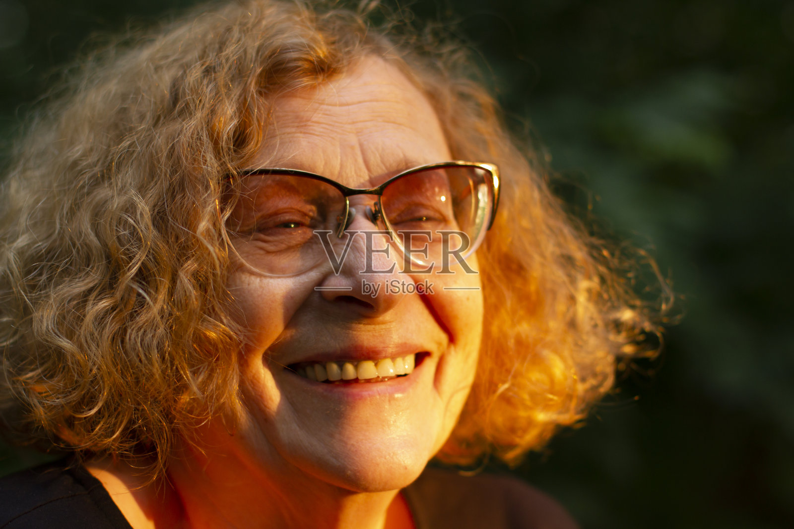 那位快乐的妇女在早晨的阳光下微笑。照片摄影图片