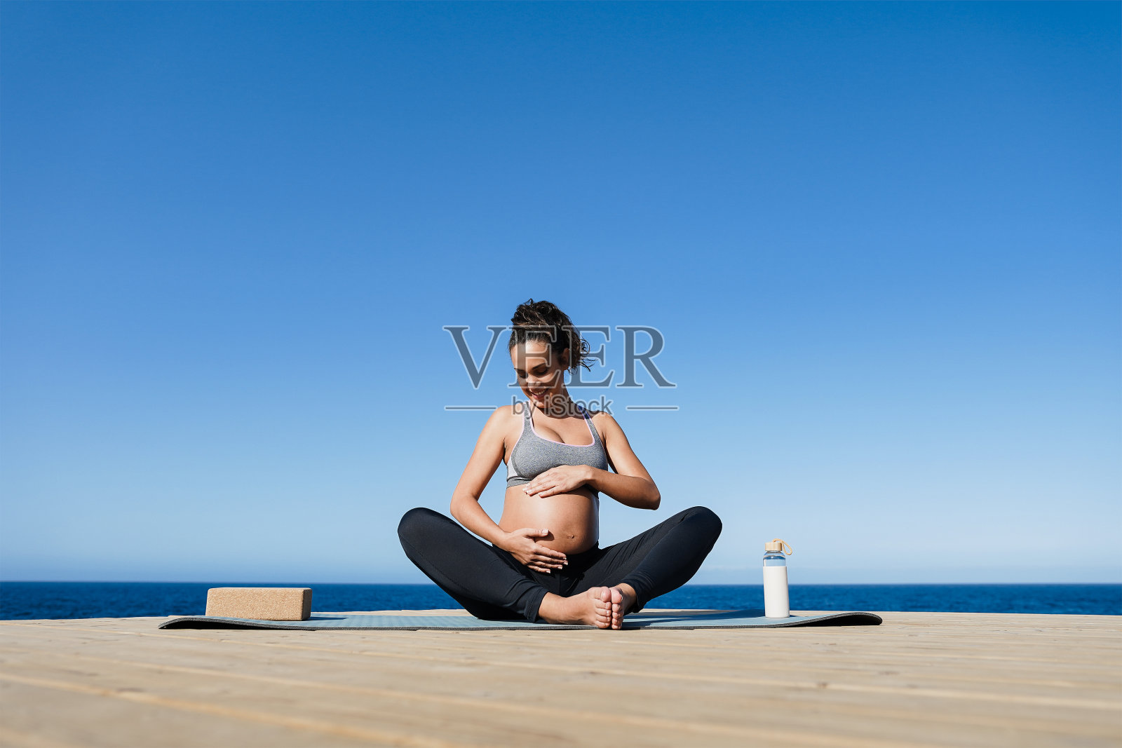 年轻孕妇在户外做瑜伽-注重面部照片摄影图片