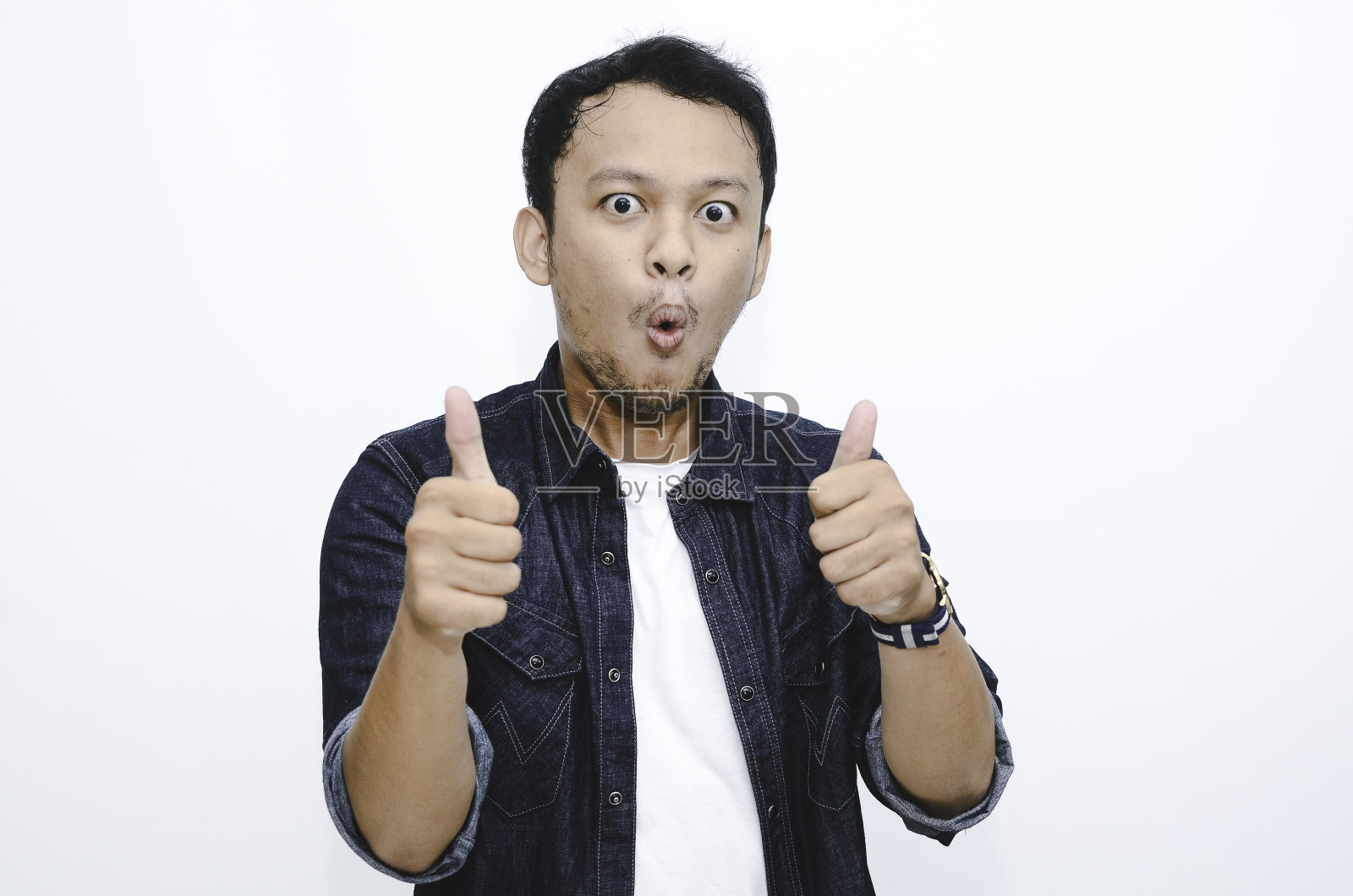 年轻的亚洲人穿着白衬衫，脸上挂着开心的笑容，竖起大拇指照片摄影图片