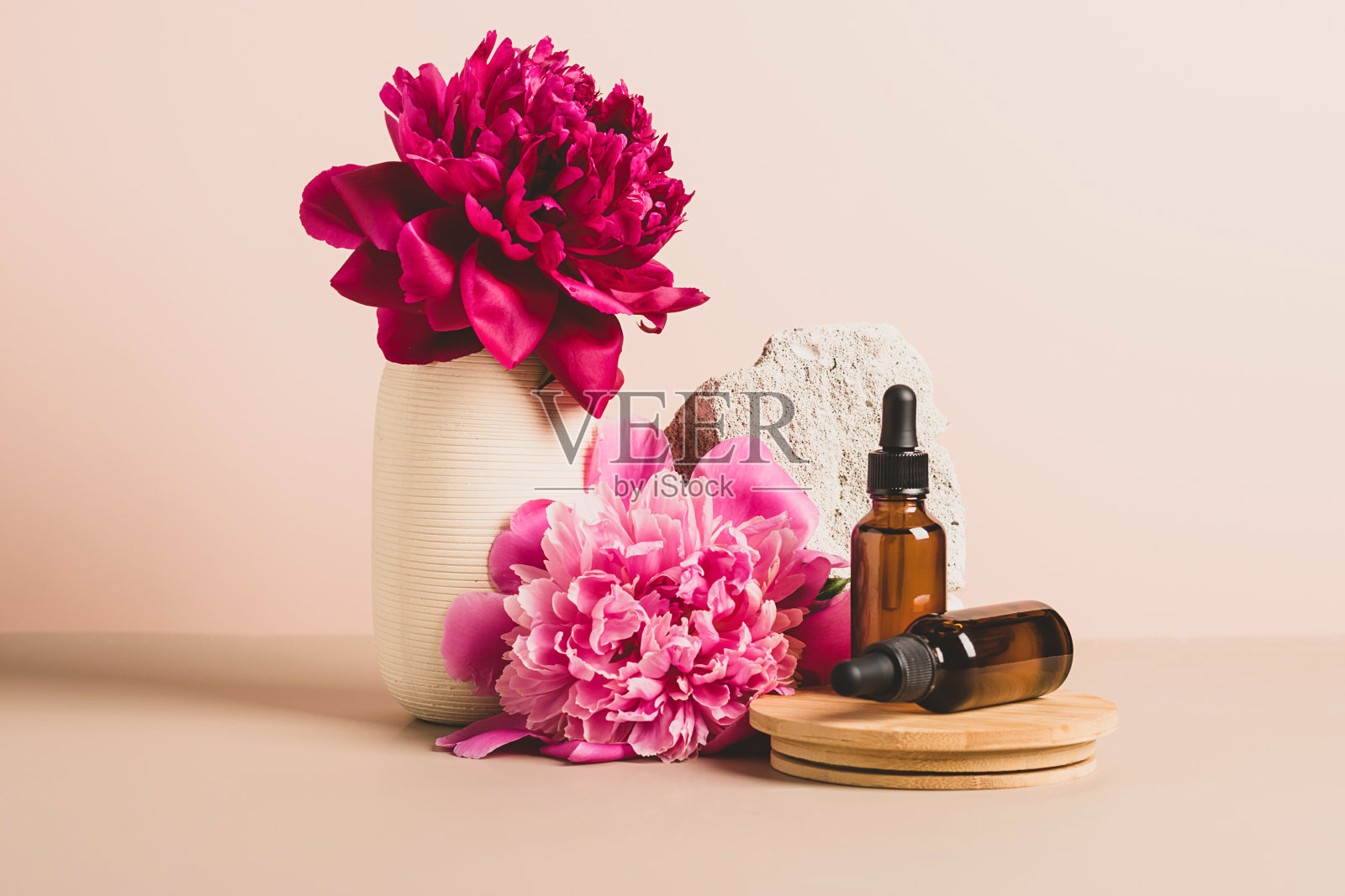 模仿玻璃滴管瓶时髦的讲台与柔和的背景，花和石头，抽象的背景照片摄影图片