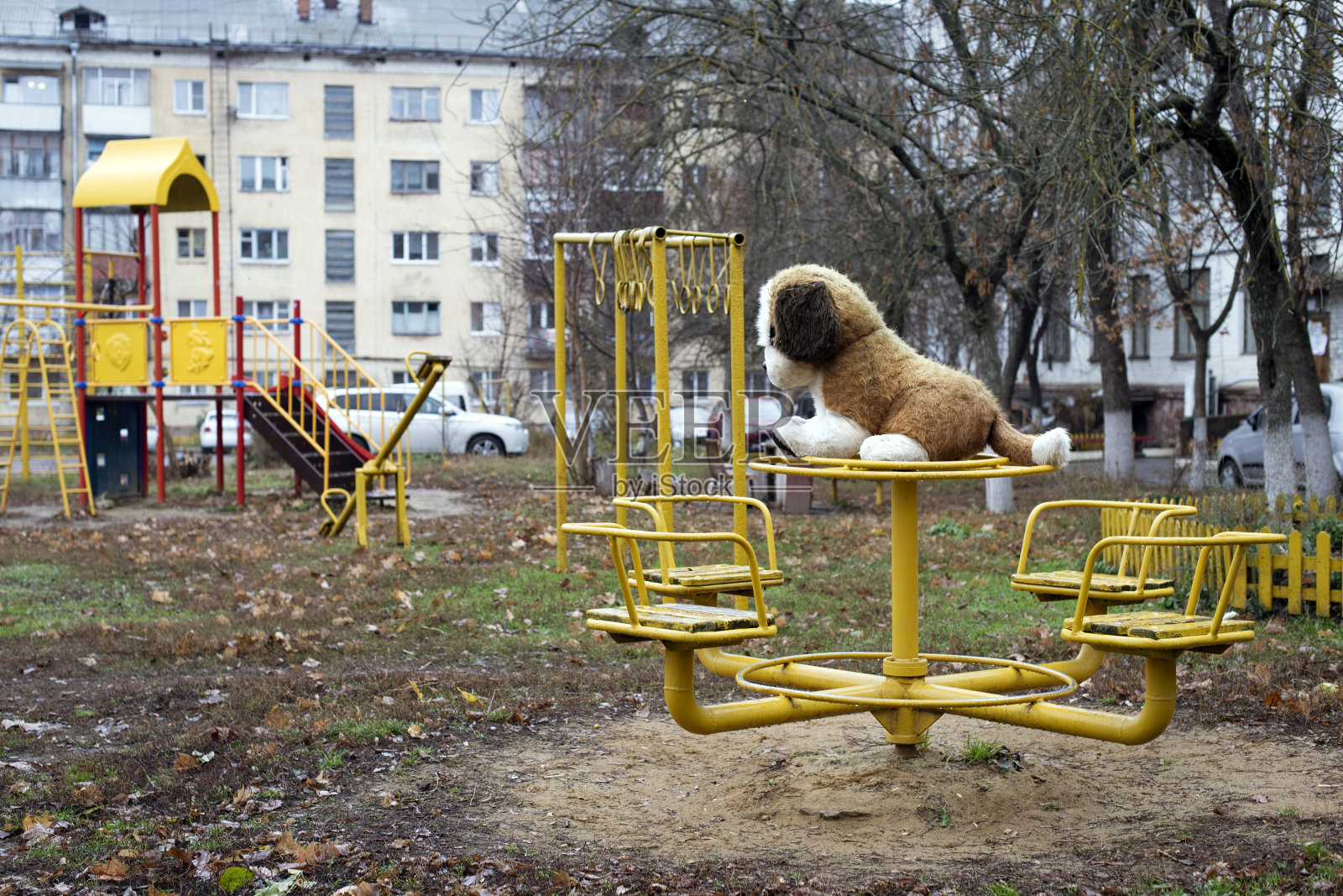 俄罗斯院子里的金属秋千上有一只柔软的大玩具狗照片摄影图片