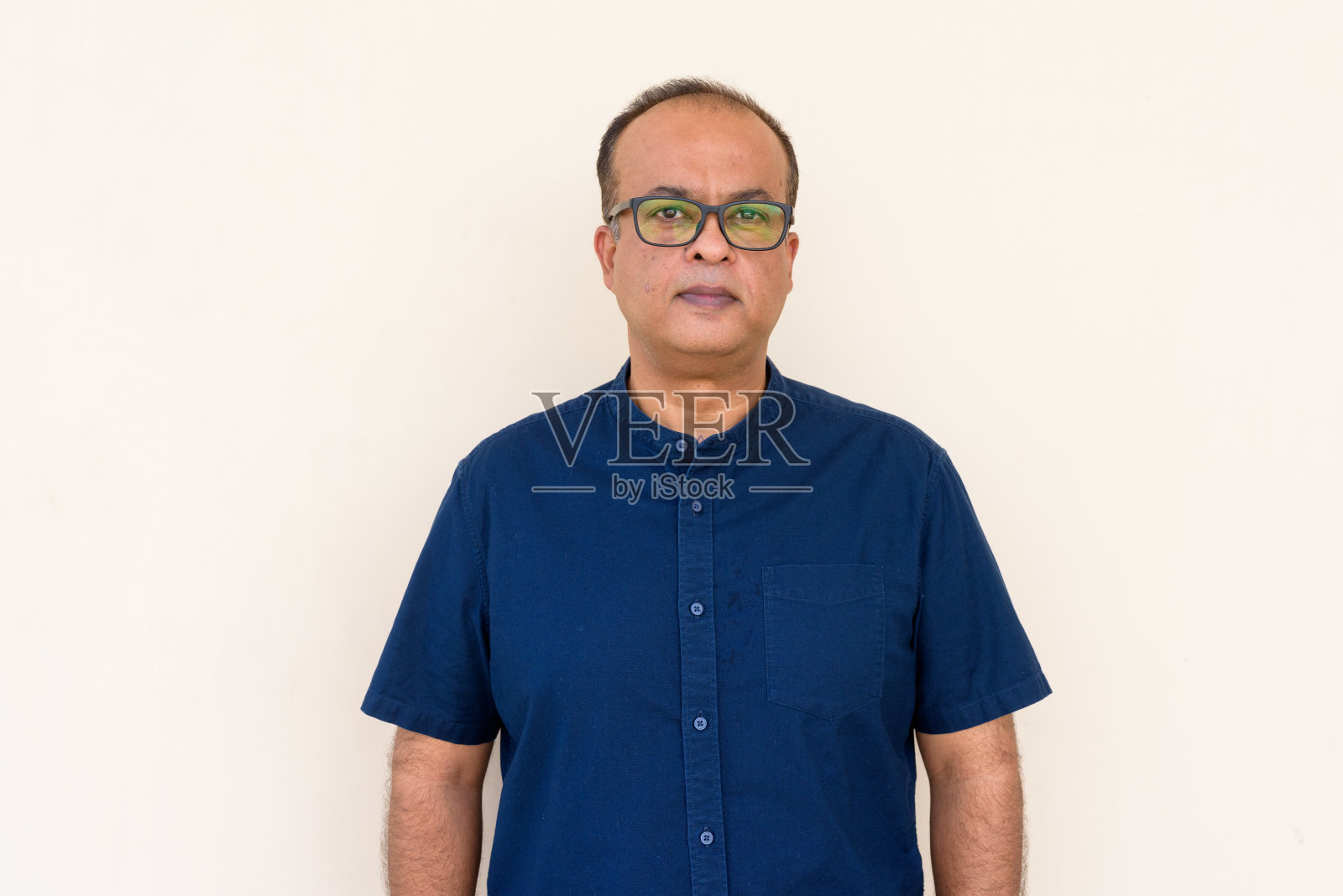 印度人的肖像靠在朴素的墙外照片摄影图片