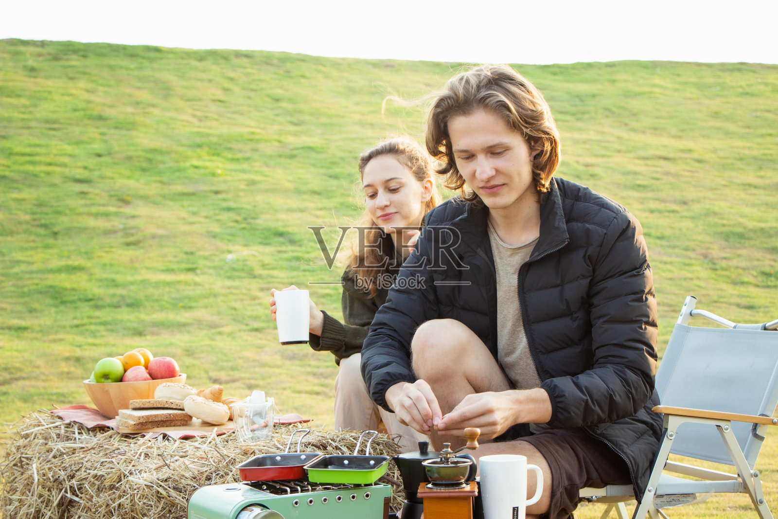 年轻夫妇喝着咖啡，弹着吉他照片摄影图片