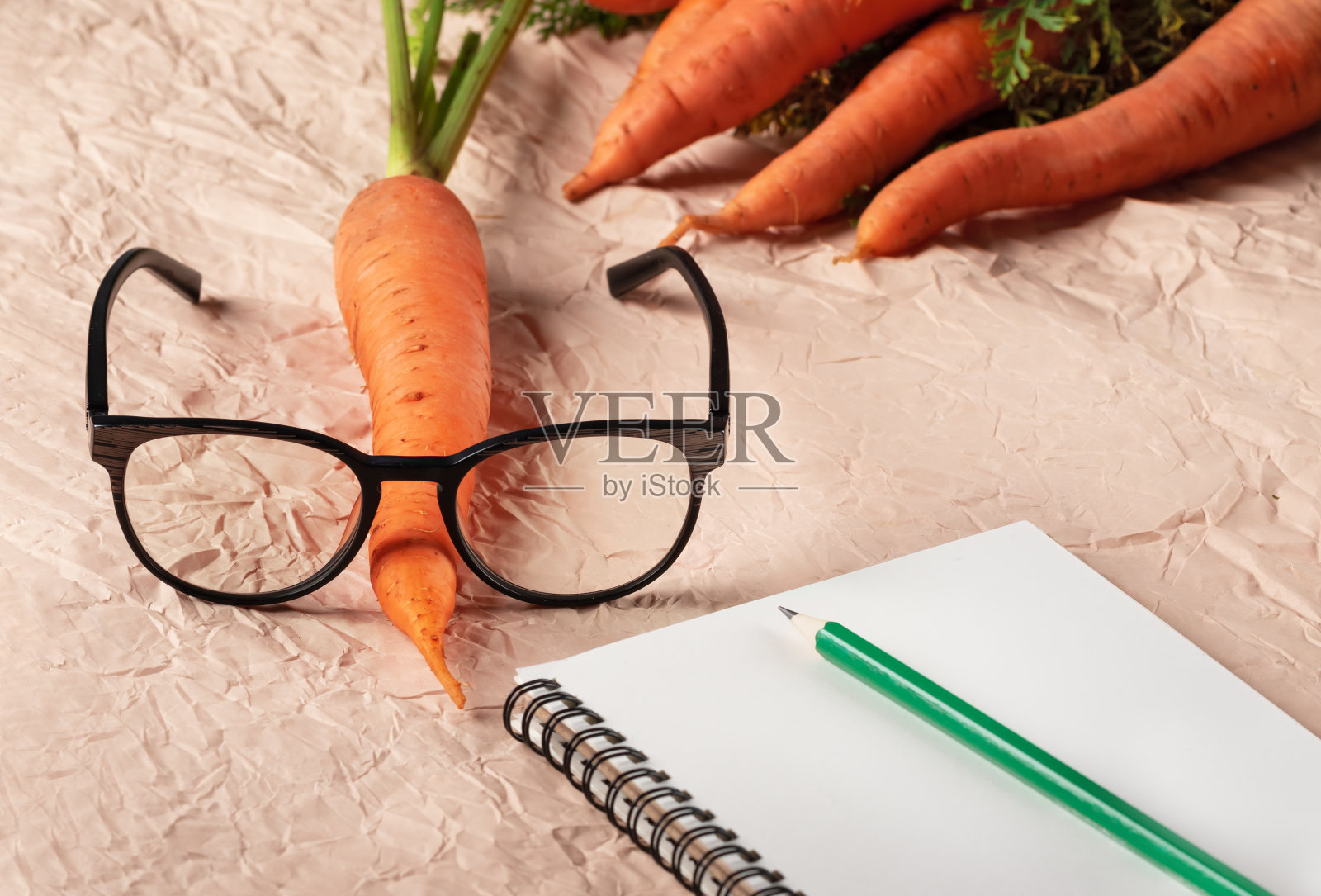 新鲜的胡萝卜和眼镜在浅色背景。照片摄影图片