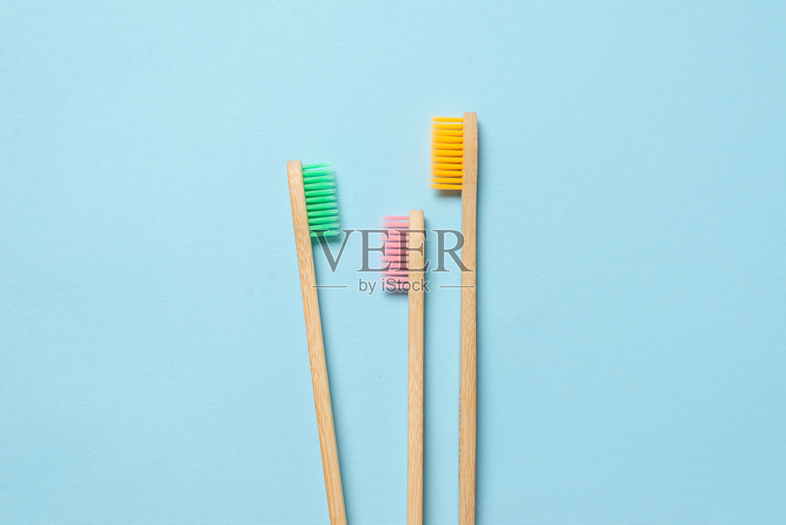 蓝色背景上的竹子牙刷。照片摄影图片