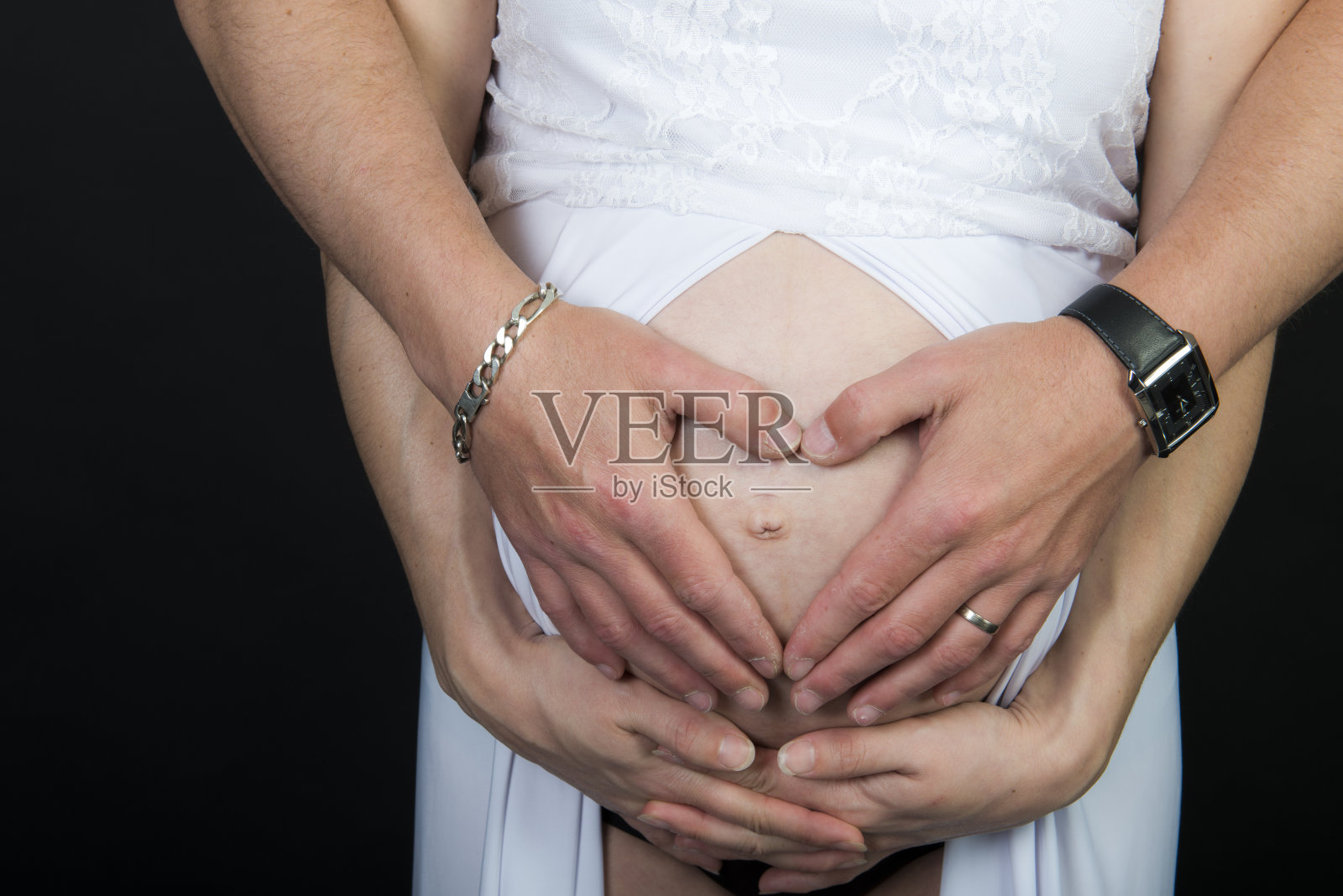 夫妻手放在怀孕的肚子上照片摄影图片