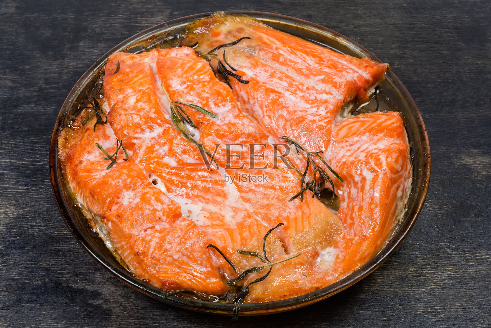 烤鳟鱼片，放在烤盘上，置于深色表面照片摄影图片