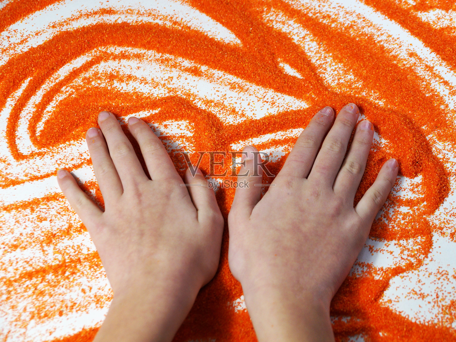 青少年在沙疗过程中手捧橙色动感沙，自闭症康复照片摄影图片