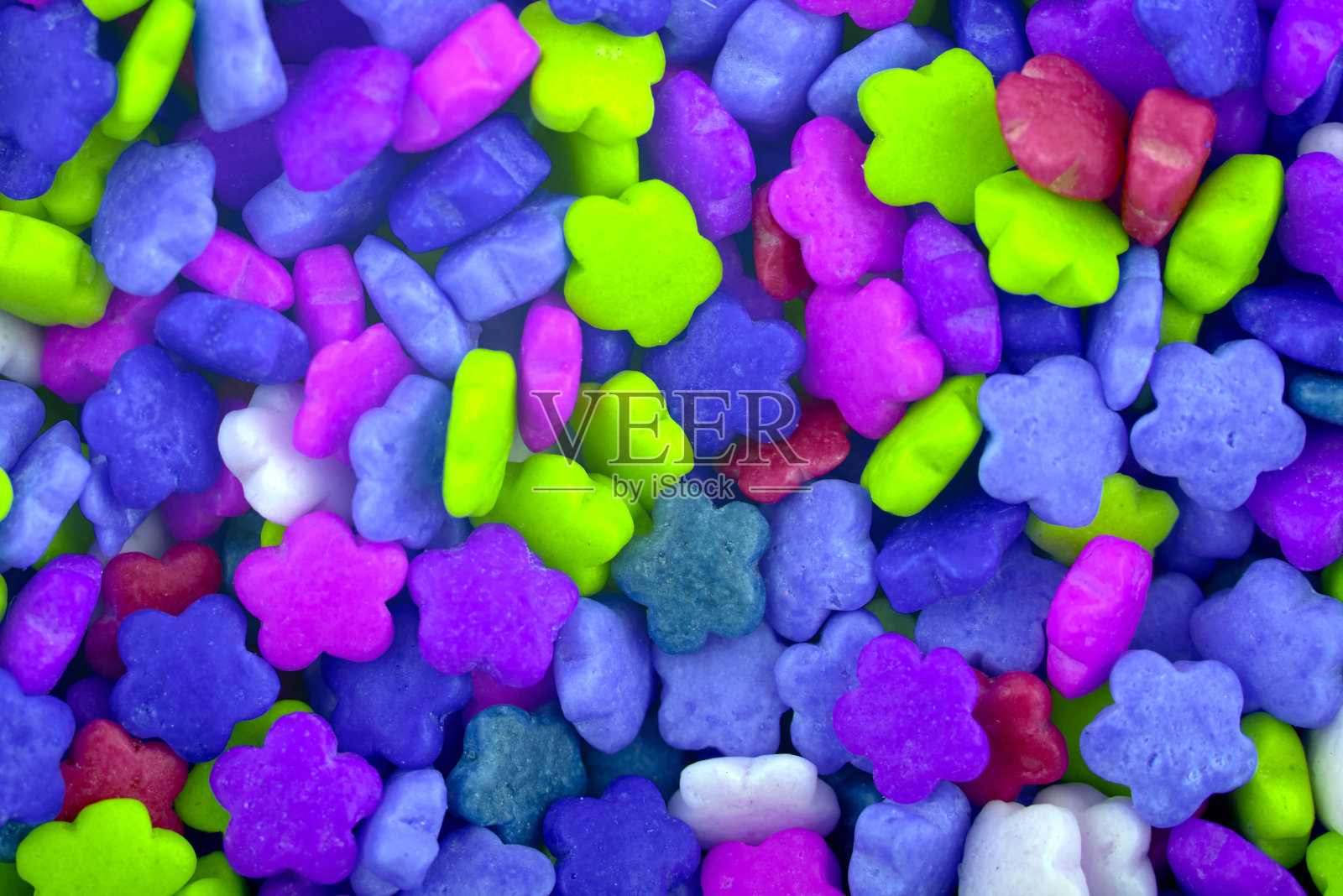 彩色糖果花背景，复制空间。一堆蓝色、绿色和紫色的巧克力糖果的特写。糖果纹理。糖果的模式。糖果的背景。俯视图，平躺照片摄影图片