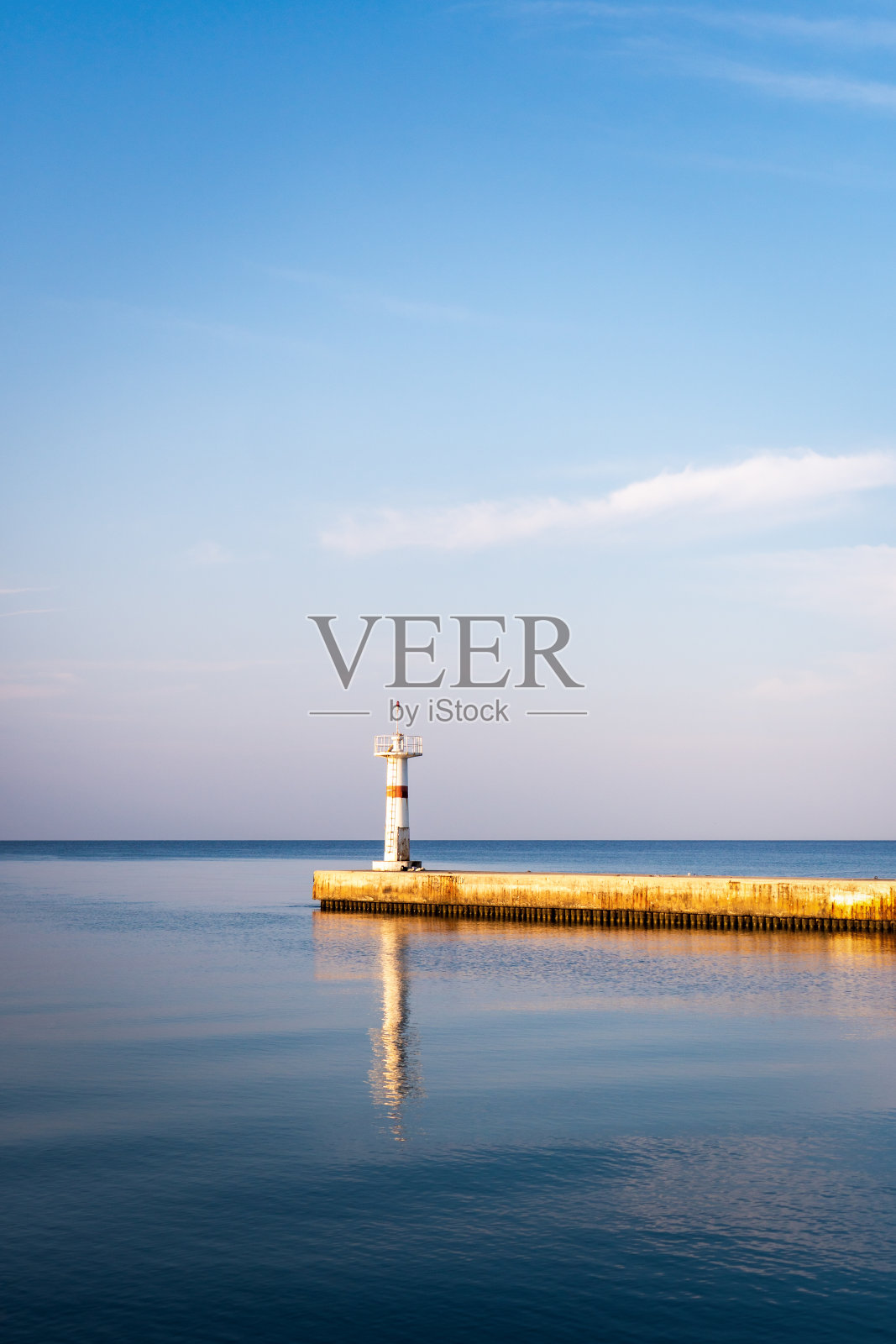 有防波堤的白色灯塔。地中海。照片摄影图片