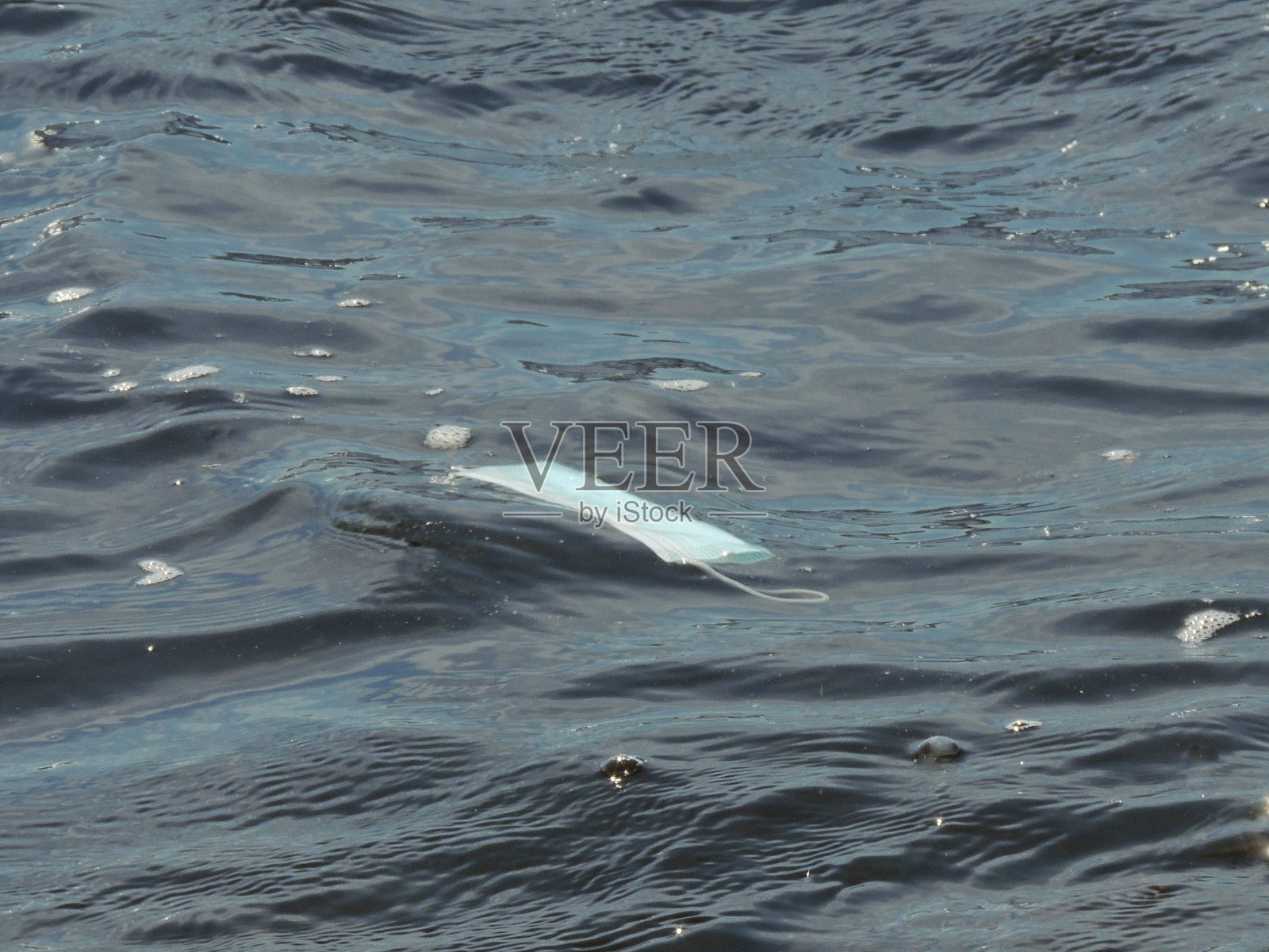 水中医用口罩。蓝色背景上是covid -19的个人防护装备。照片摄影图片