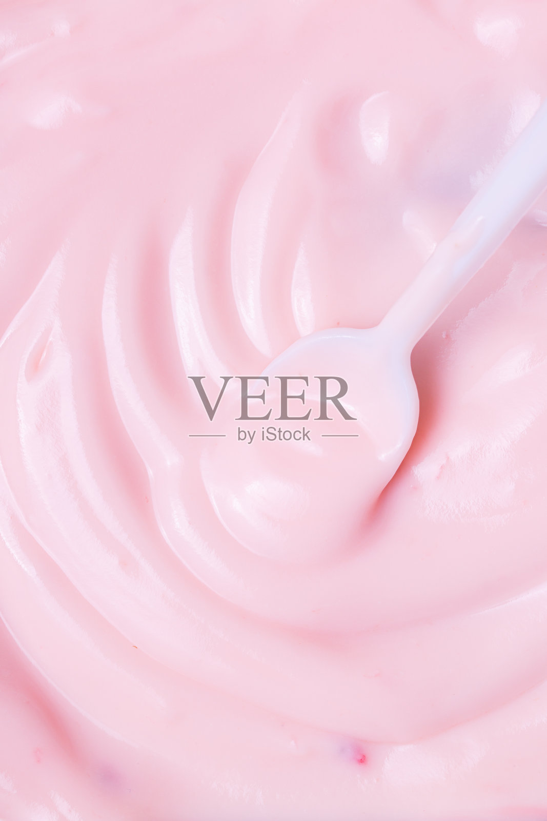 宏酸奶，草莓冰冻酸奶背景特写。草莓冰淇淋质地接近。前视图。粉红色水果冰淇淋的背景与小块浆果照片摄影图片