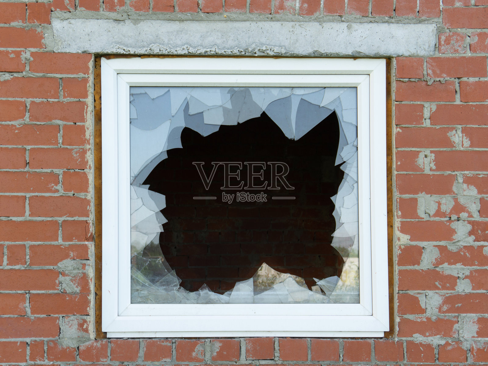 红砖墙上的破窗。破窗的黑暗。照片摄影图片