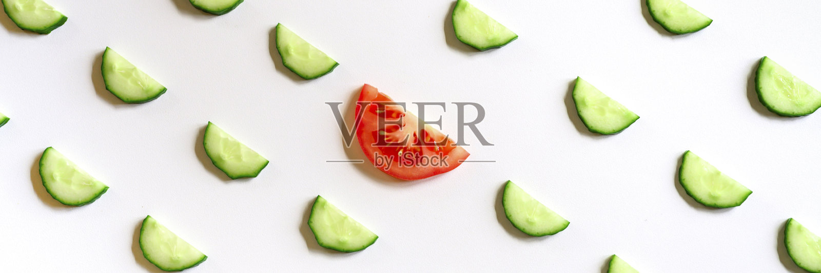 半圆形的新鲜生蔬菜黄瓜，用于沙拉和一片番茄在中心孤立在白色背景平铺，俯视图。横幅照片摄影图片