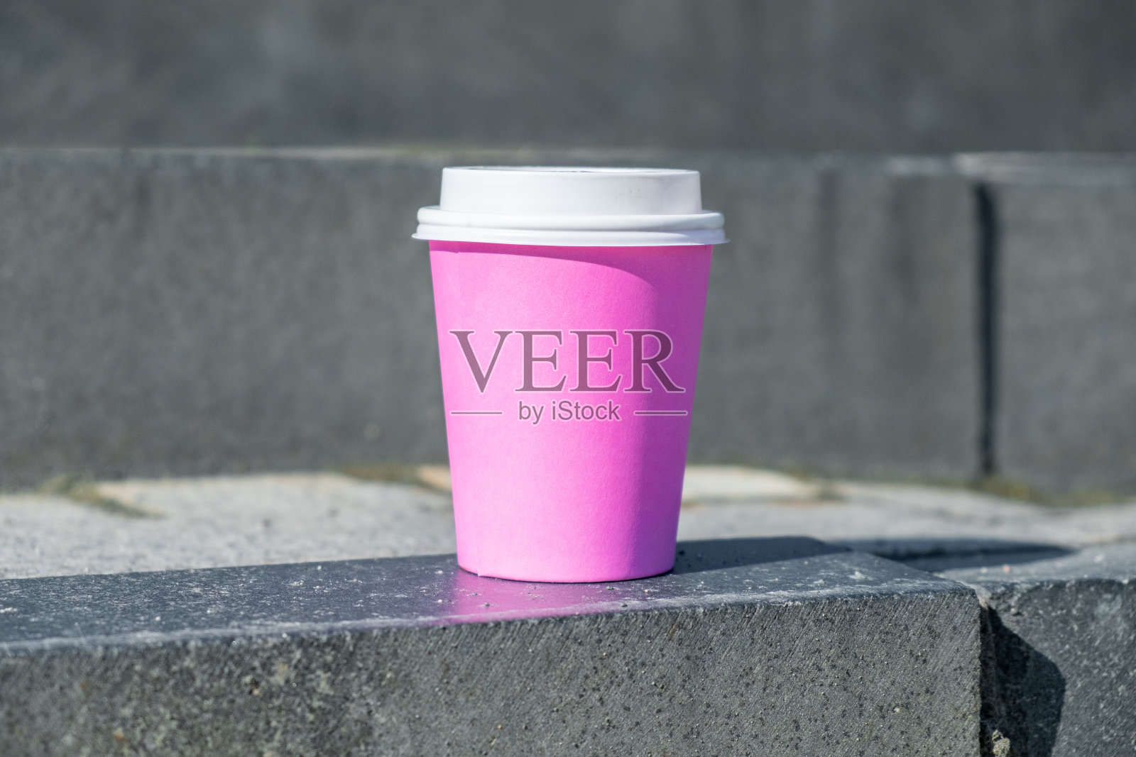一次性的粉色咖啡杯在街上拷贝空间。照片摄影图片