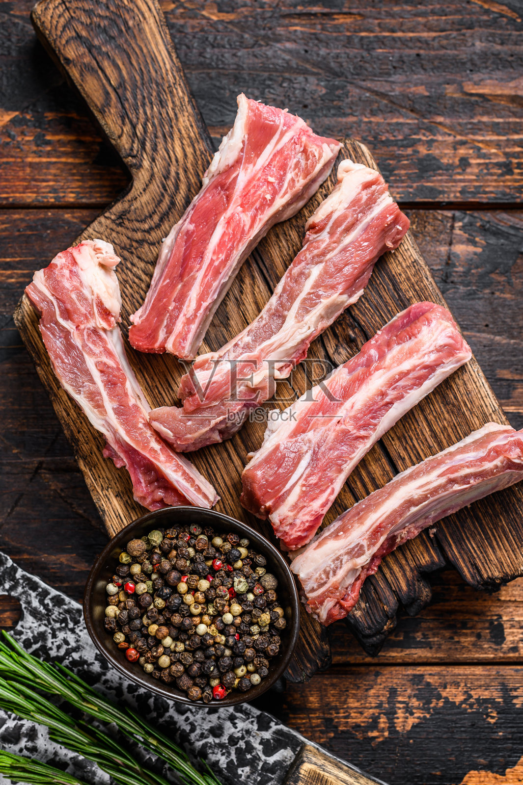 生小牛肉切成薄片，放在木制砧板上。黑色背景。俯视图照片摄影图片