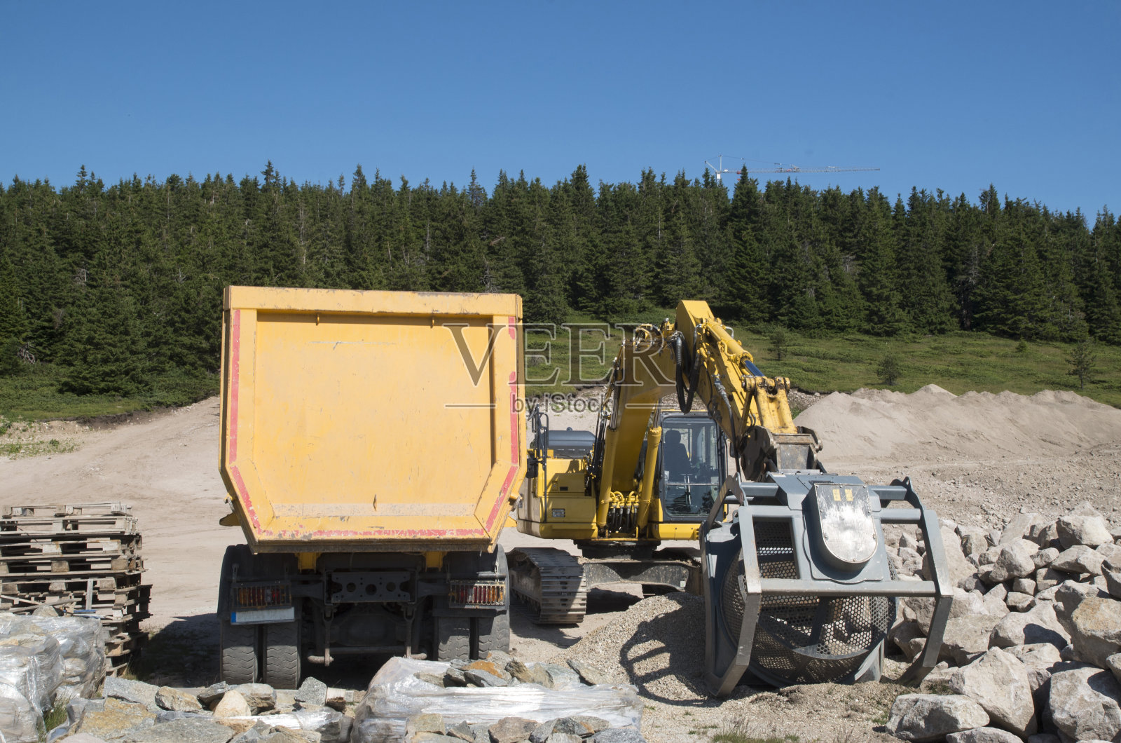 履带式挖掘机，用于采石场分选石头和卡车的筛选和研磨桶照片摄影图片