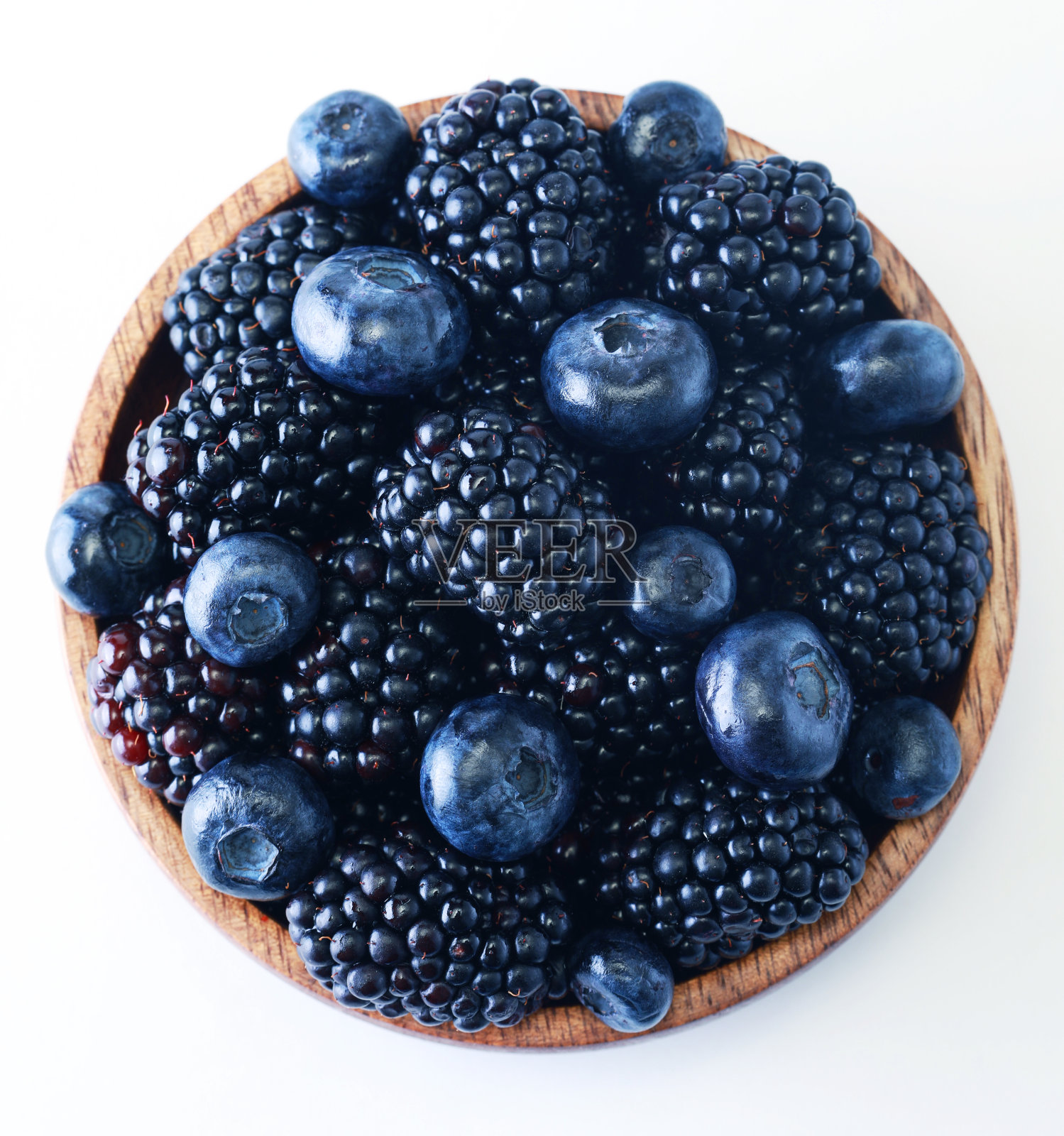 黑莓和蓝莓放在白色背景的木碗里照片摄影图片