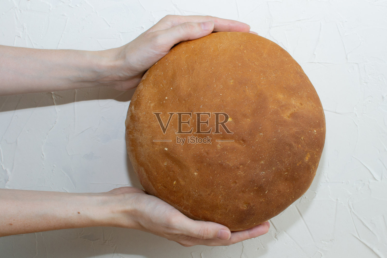 两只手捧着自制的面包。照片摄影图片