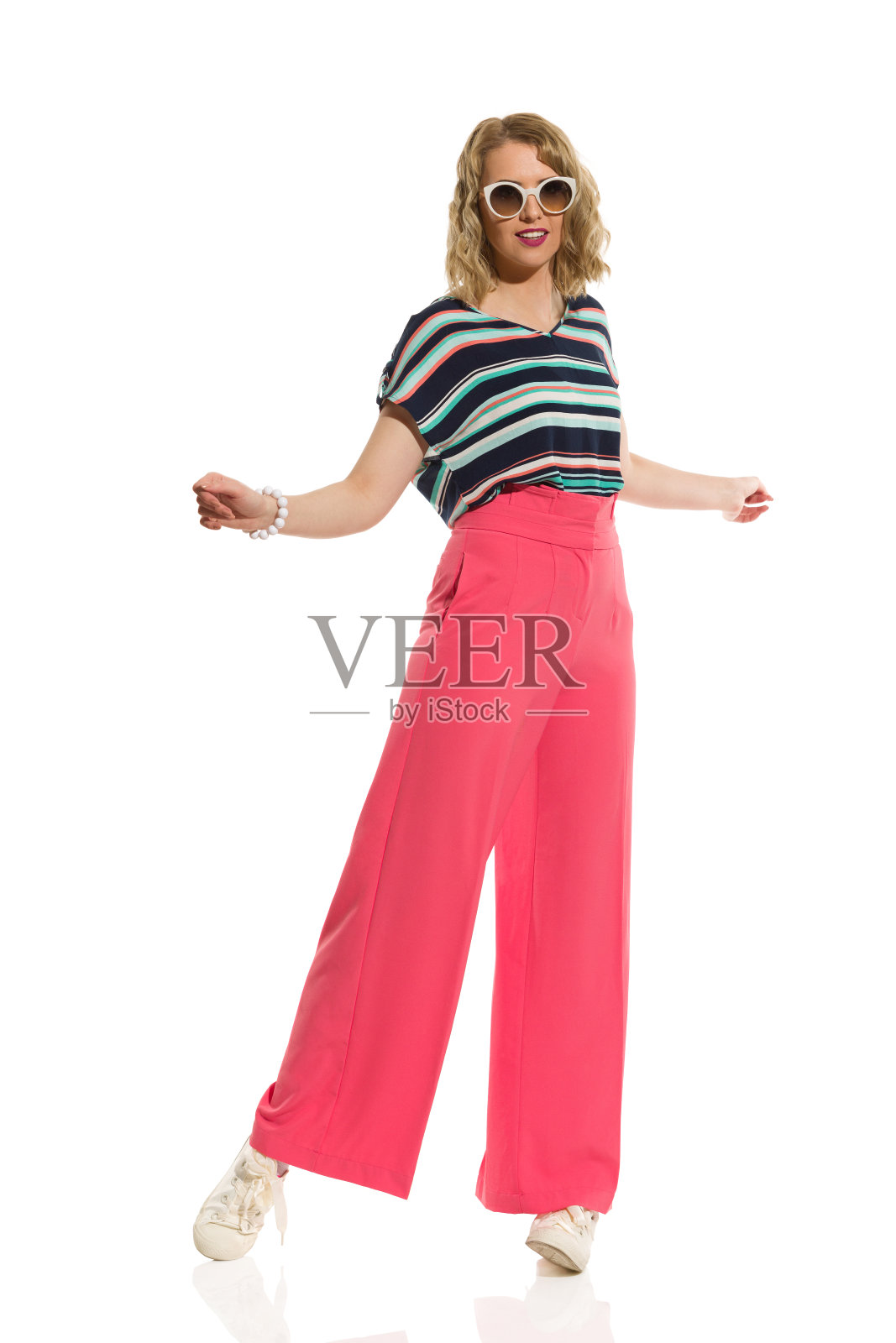 穿着红色阔腿裤和太阳镜的年轻女子照片摄影图片