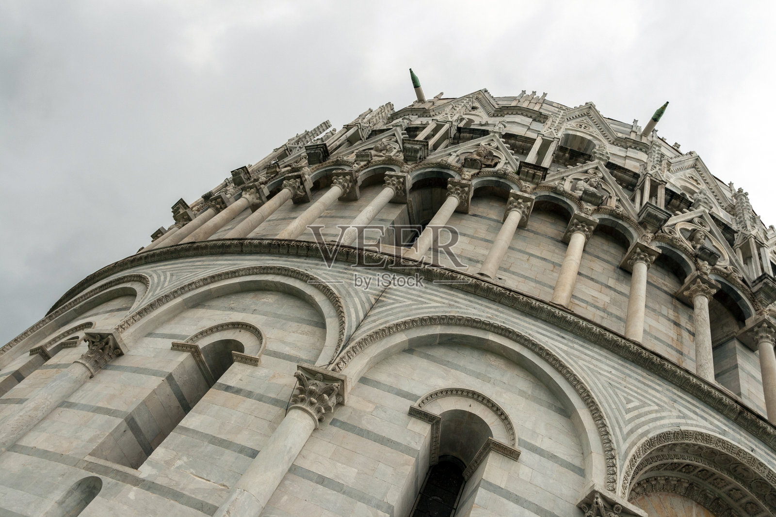 下雨天，意大利比萨圣奇迹广场的比萨洗礼堂。照片摄影图片