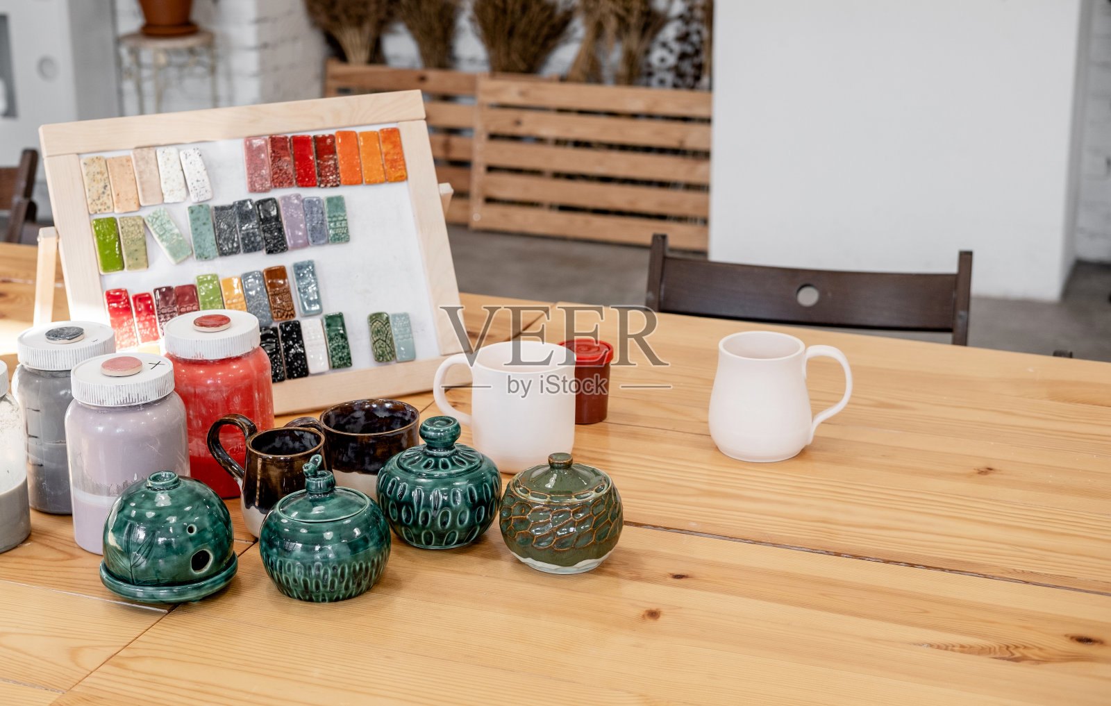 手工制作的陶瓷陶器。白色的，没有彩绘的陶土站在桌上。波特创意工作室。照片摄影图片