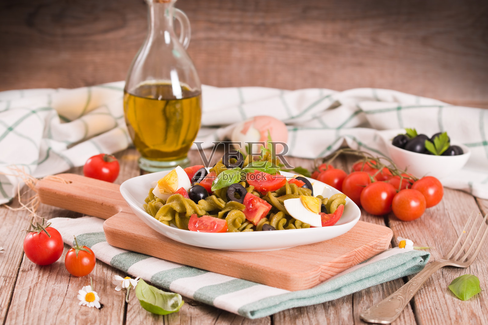 意大利通心粉配樱桃番茄，鸡蛋和黑橄榄。照片摄影图片