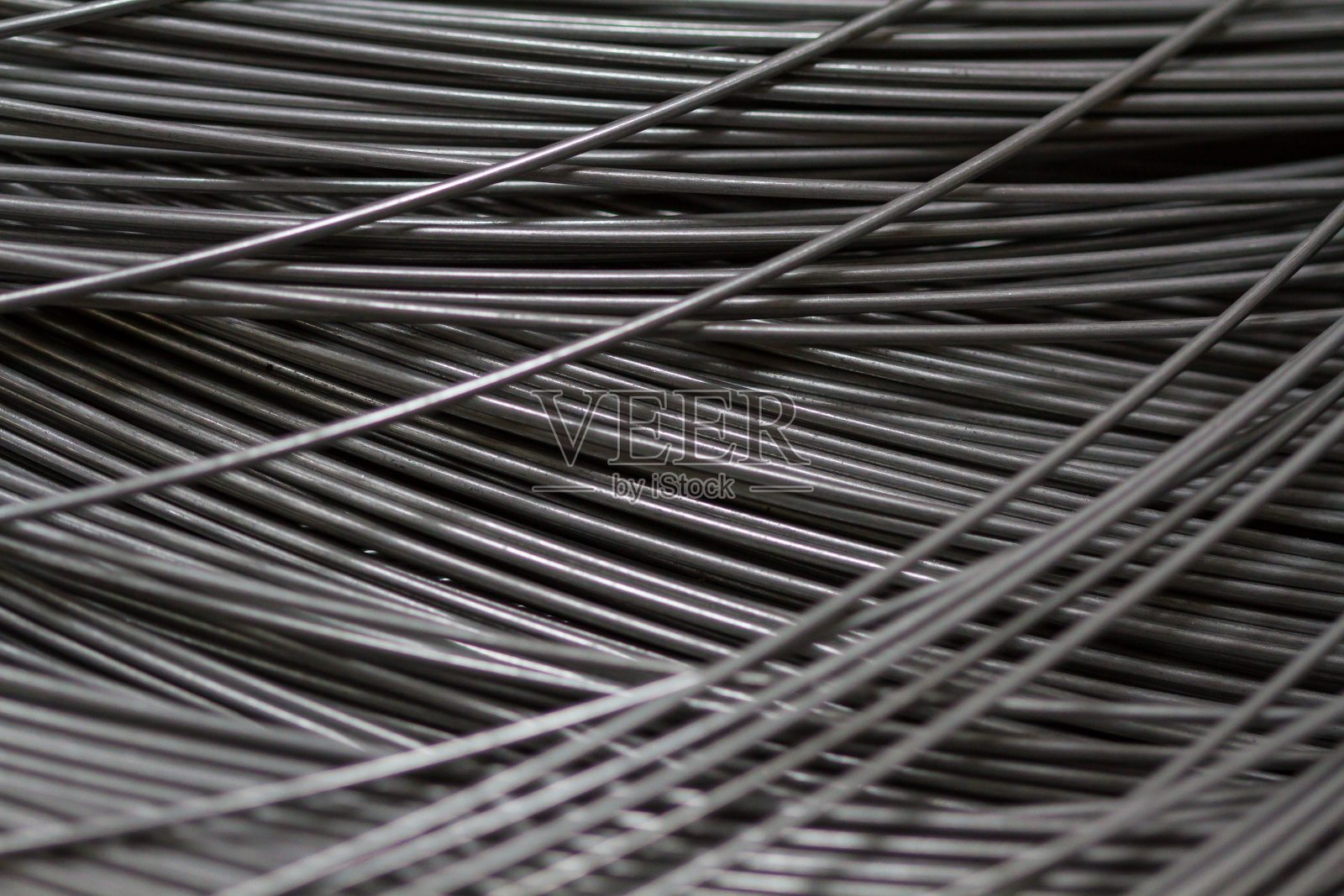 生产车间或施工现场使用不锈钢丝。用于弹簧生产或混凝土加固的丝辊的特写镜头。金属质感。工业或建筑概念。照片摄影图片