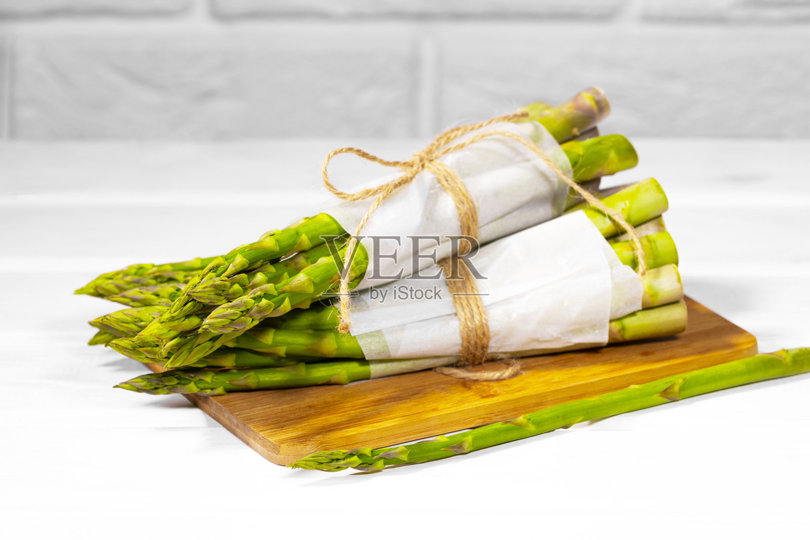 鲜绿芦笋在白色背景的木桌。健康的蔬菜的饮食。素食主义。蔬菜壁纸。照片摄影图片