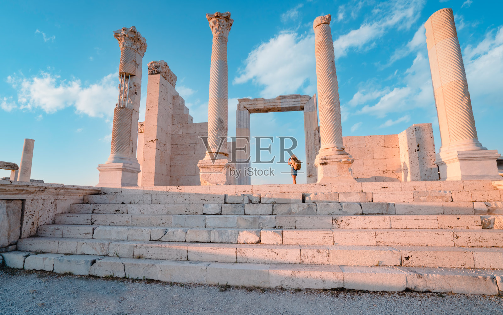 旅行者旅行者摄影师女孩在黄昏时在吕库斯老底嘉古城遗址的老底嘉教堂拍照照片摄影图片