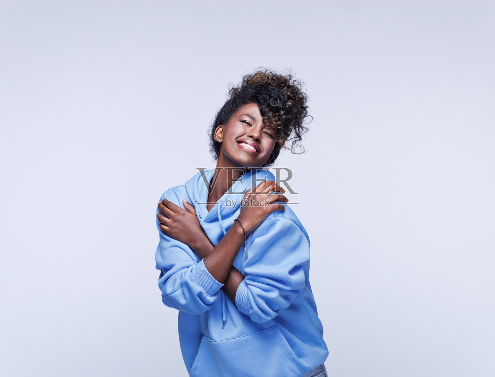 穿着蓝色连帽衫的快乐年轻女子照片摄影图片